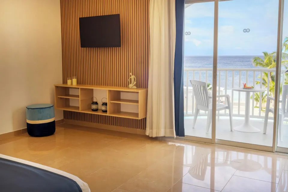 Sea View room TV wall and furnished balcony facing the ocean at HM Alma de Bayahibe.