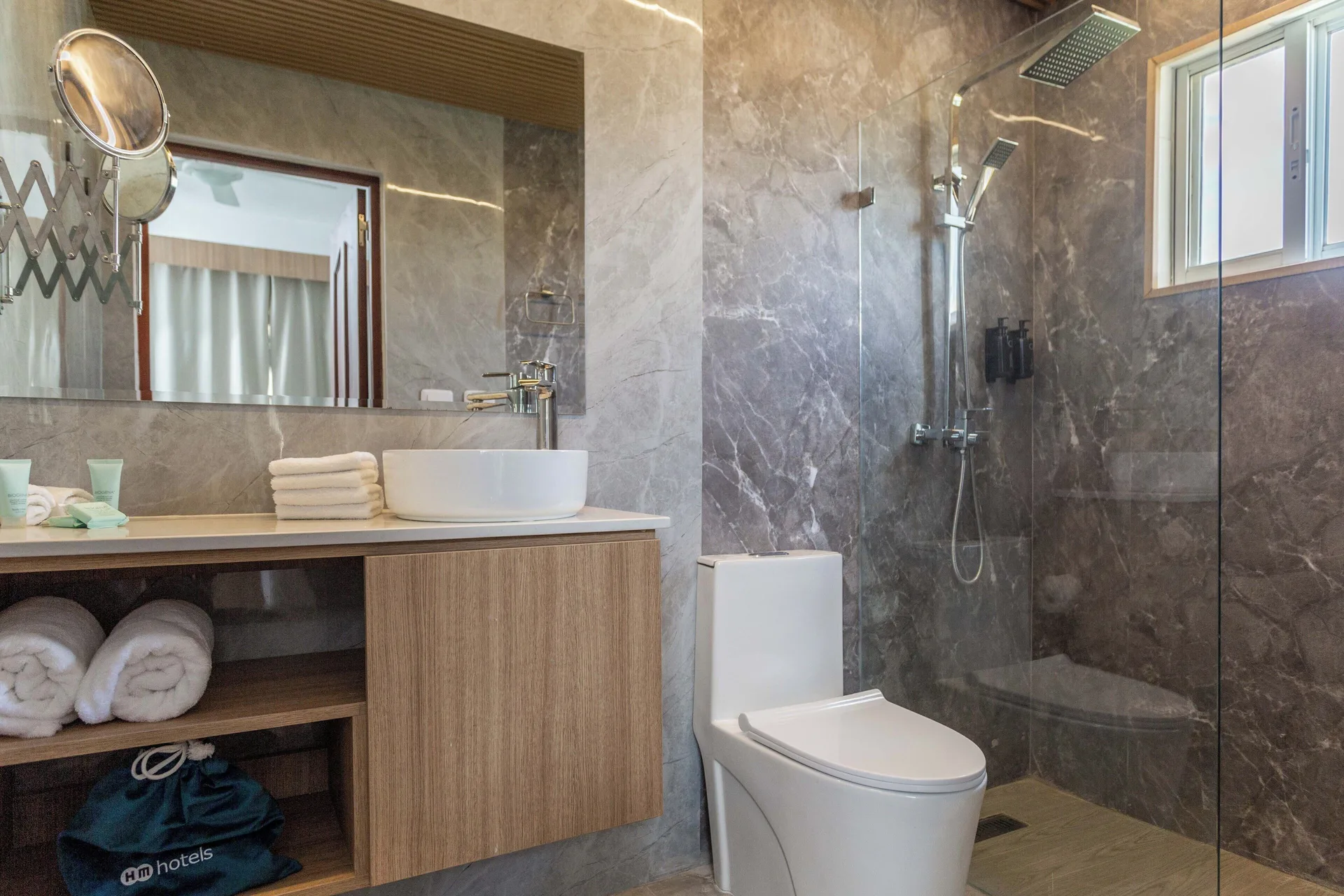 Guest bathroom with vessel sink, toilet and glass shower at HM Alma de Bayahibe.