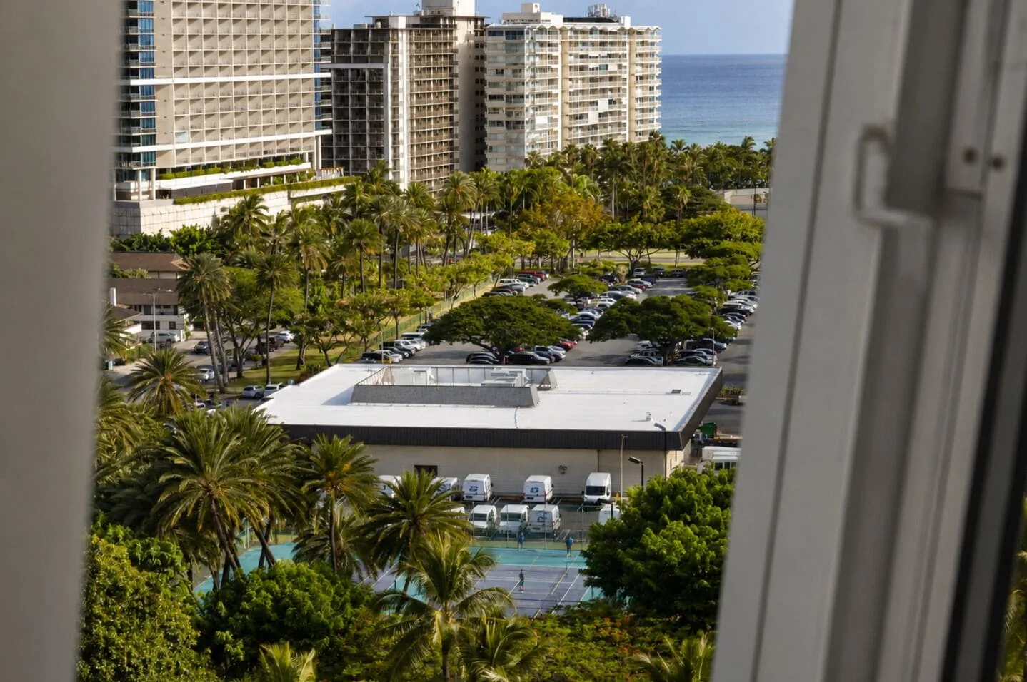 Ocean, palms, and city buildings seen from Penthouse Hoku at Hotel La Croix.