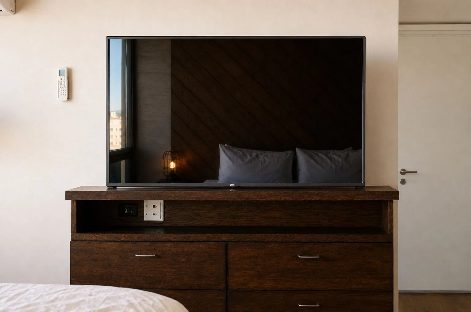 Penthouse Hoku Skyline Honolulu TV and dresser facing the bed at Hotel La Croix.