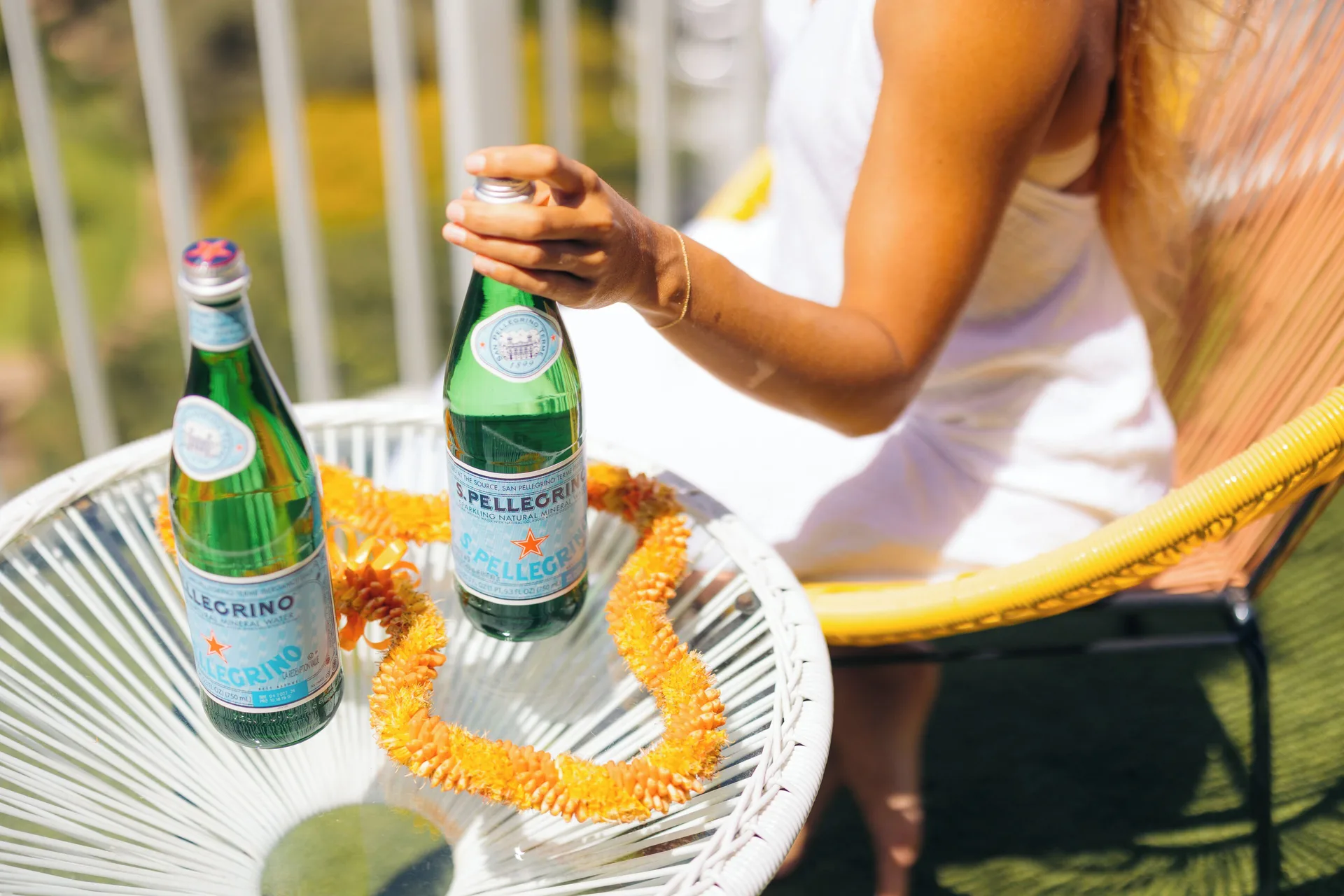 Balcony table with bottled sparkling water and a lei at Hotel La Croix.