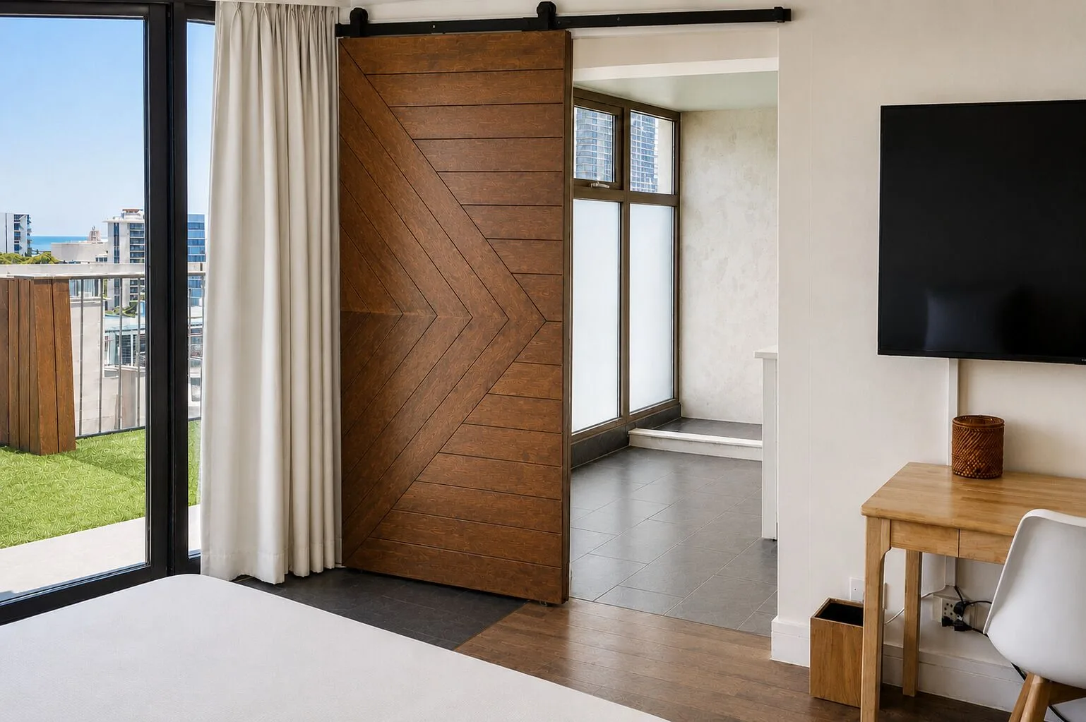 Penthouse Hoku Terrace Oceanview room with terrace doors, barn door, desk, and TV at Hotel La Croix.