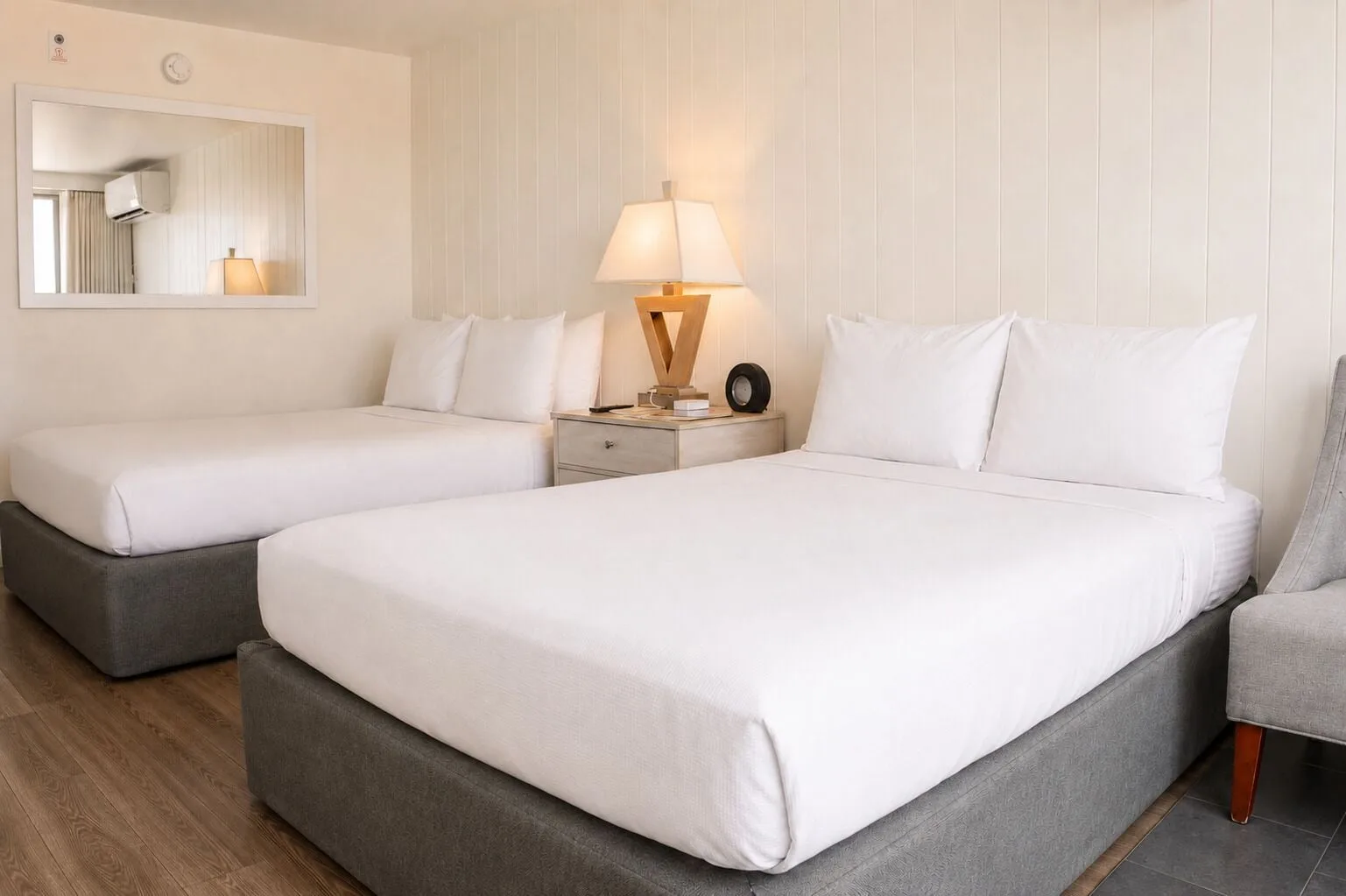 Penthouse Hoku Terrace Oceanview room with two beds, mirror, lamp, and chair at Hotel La Croix.