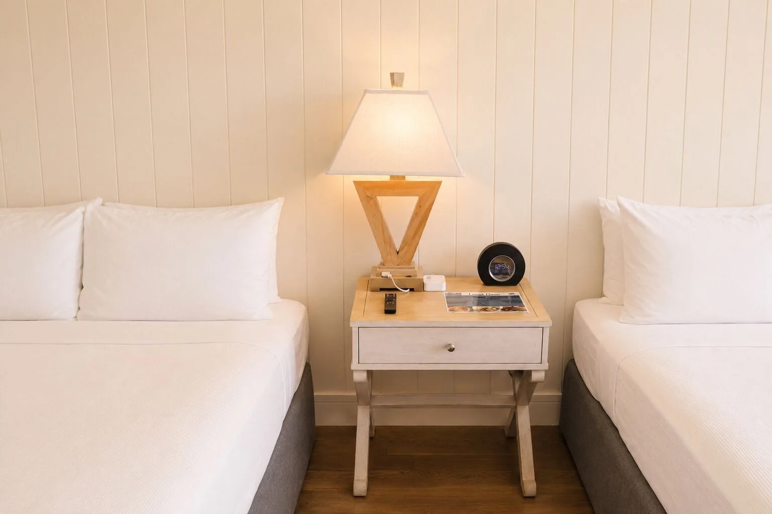 Two beds flank a nightstand with a lit lamp in Penthouse Hoku Terrace Oceanview at Hotel La Croix.