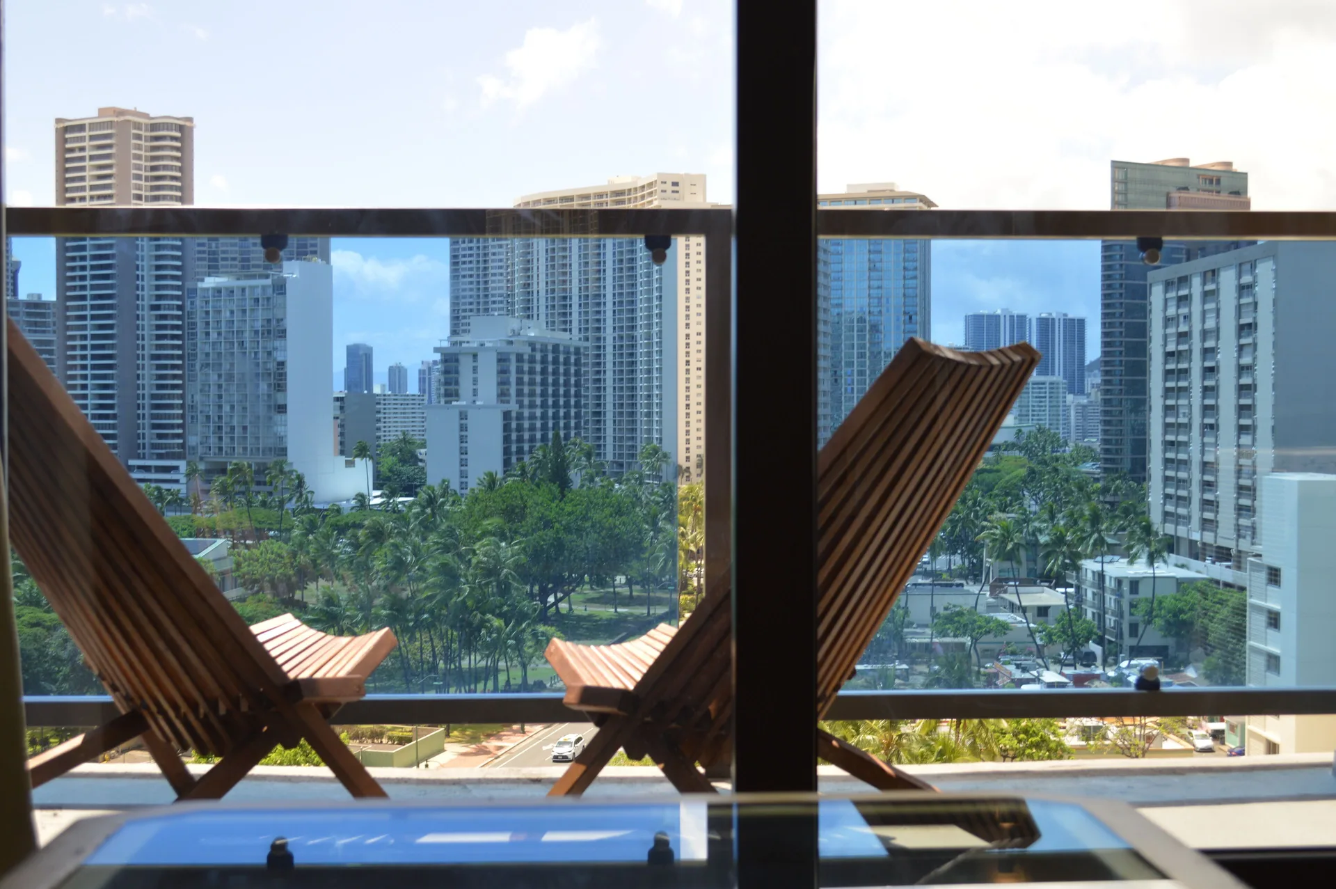 Lanai chairs and skyline view from a Premium Kalakaua Haus room at Hotel La Croix.