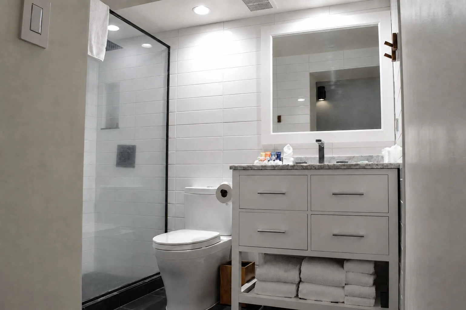 Premium Kalakaua Haus bathroom with glass shower, toilet, and vanity at Hotel La Croix.