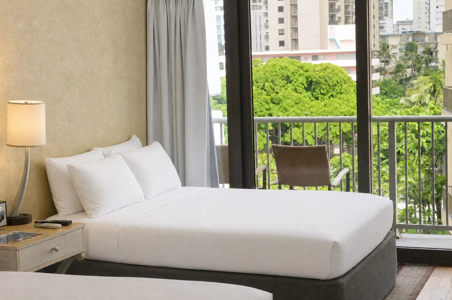 Premium Kalakaua Haus Kitchenette bed beside balcony doors at Hotel La Croix.