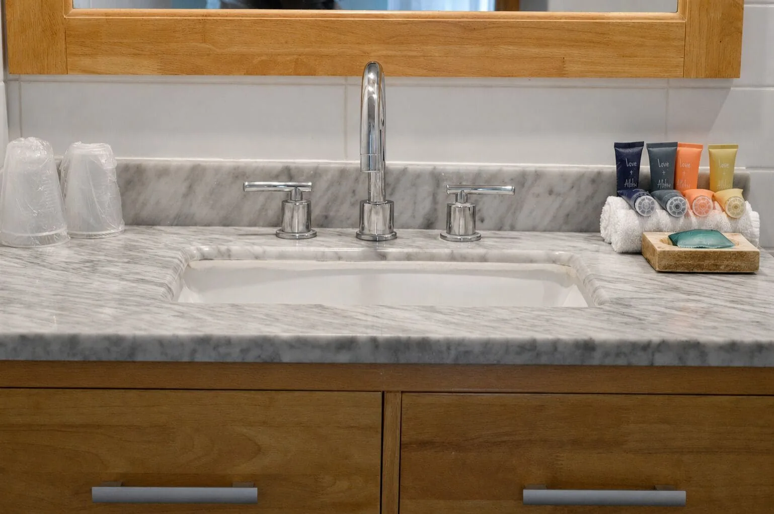 Close-up of the marble-look bathroom sink and toiletries at Hotel La Croix.