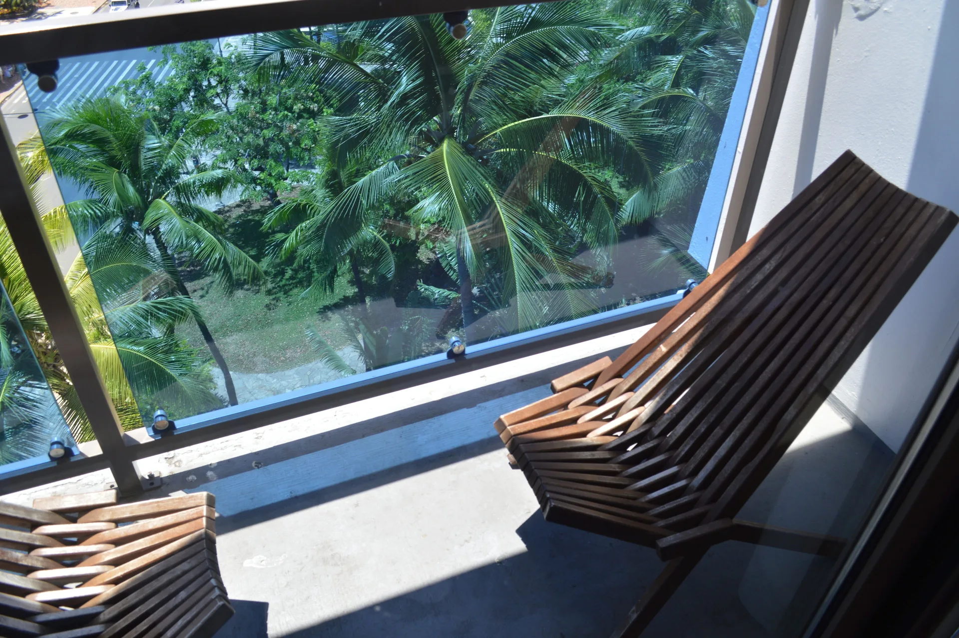 Wood lounge chairs on the lanai of a Premium Kalakaua Haus room at Hotel La Croix.