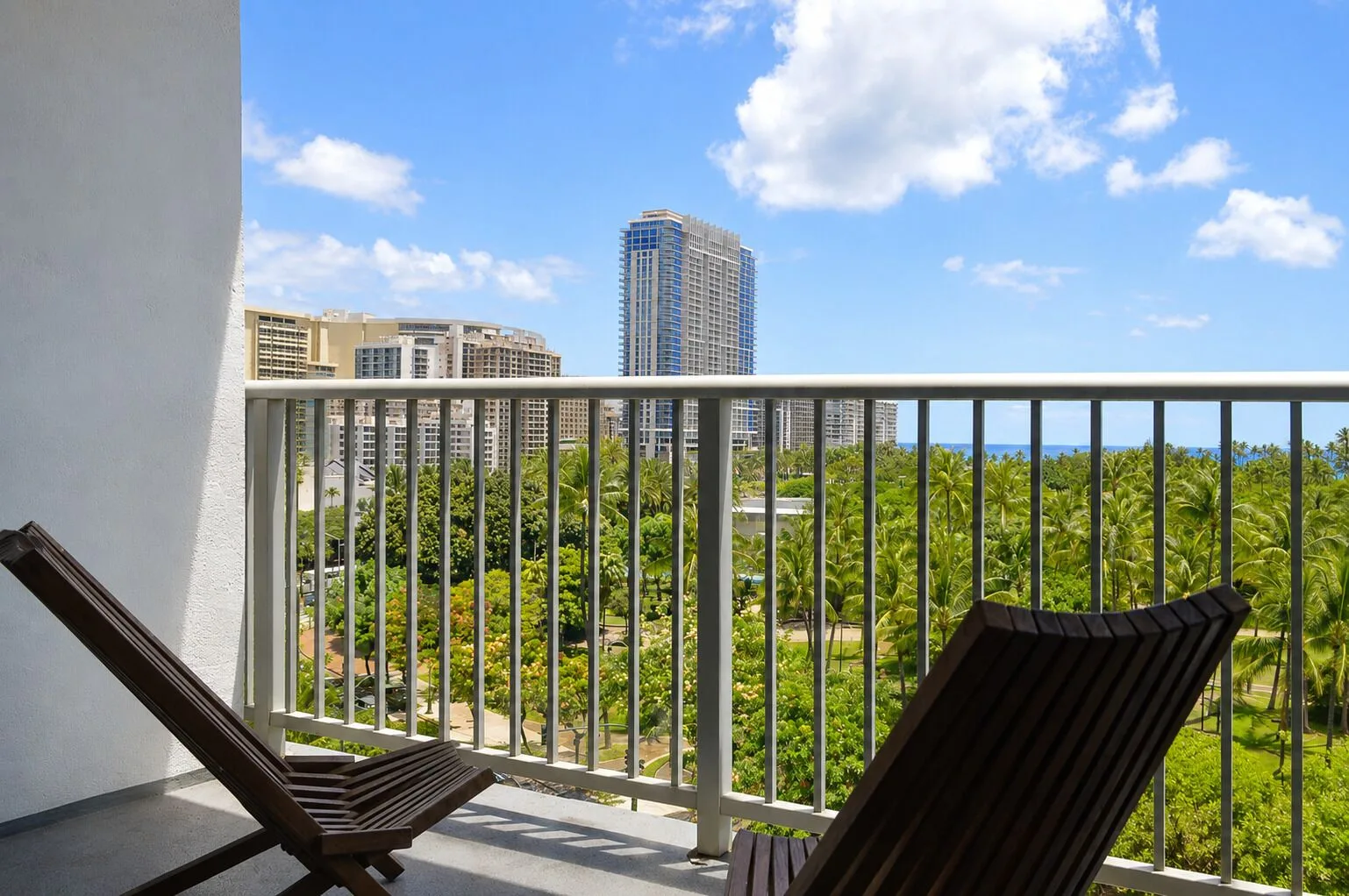 Lanai chairs face palm trees, towers, and ocean at Hotel La Croix.