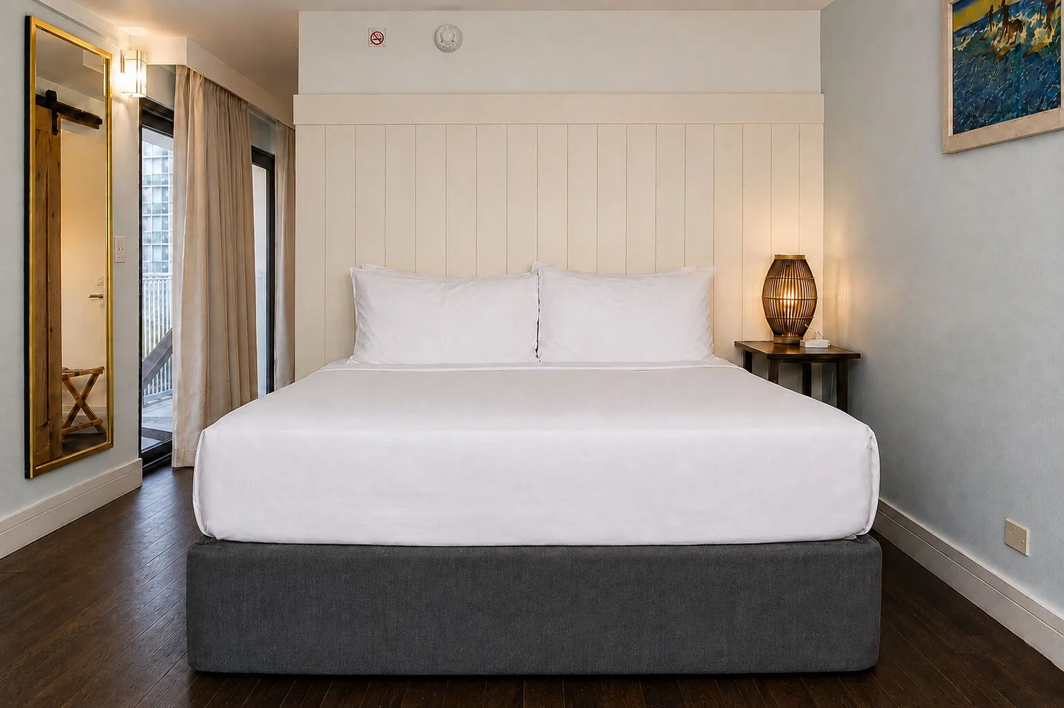 King bed with white linens in a Premium Kalakaua Haus room at Hotel La Croix.