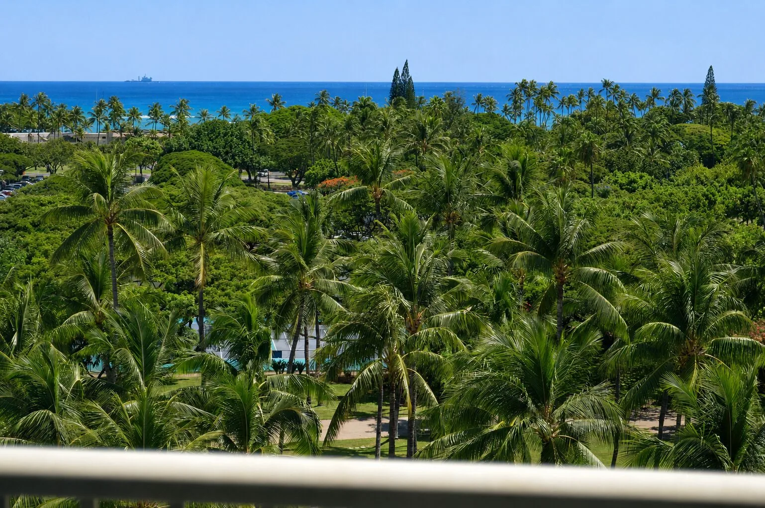 Premium Kalakaua Haus Oceanview lanai view over palms to the ocean at Hotel La Croix.
