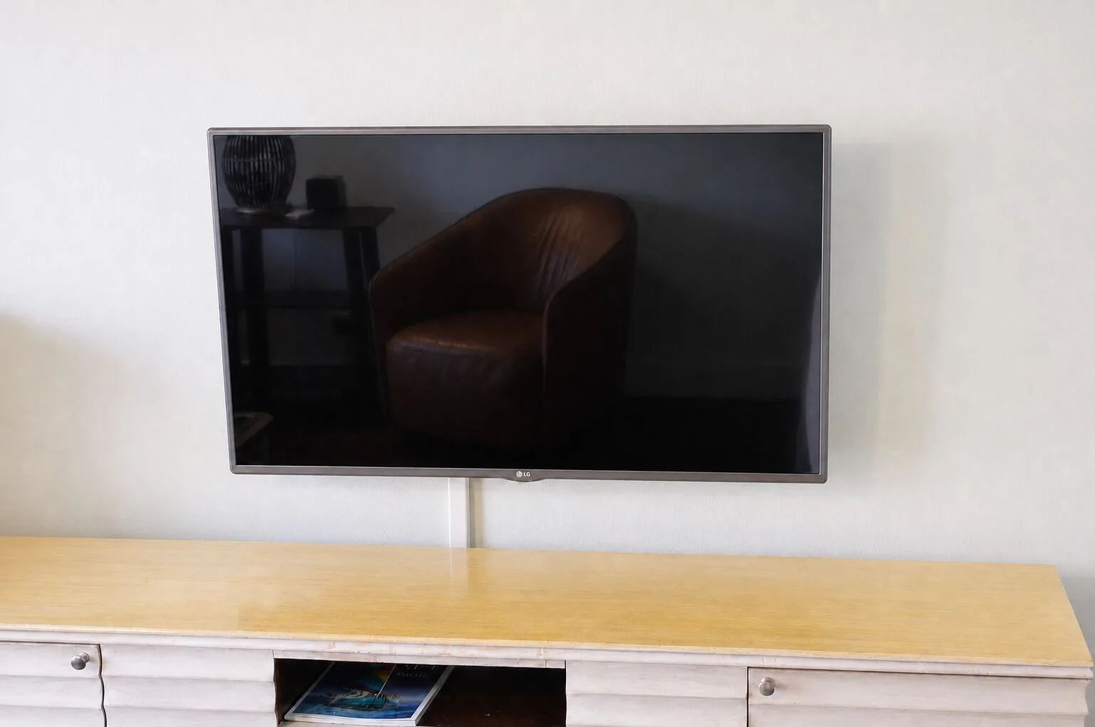Flat-screen TV above a dresser in a Premium Kalakaua Haus room at Hotel La Croix.