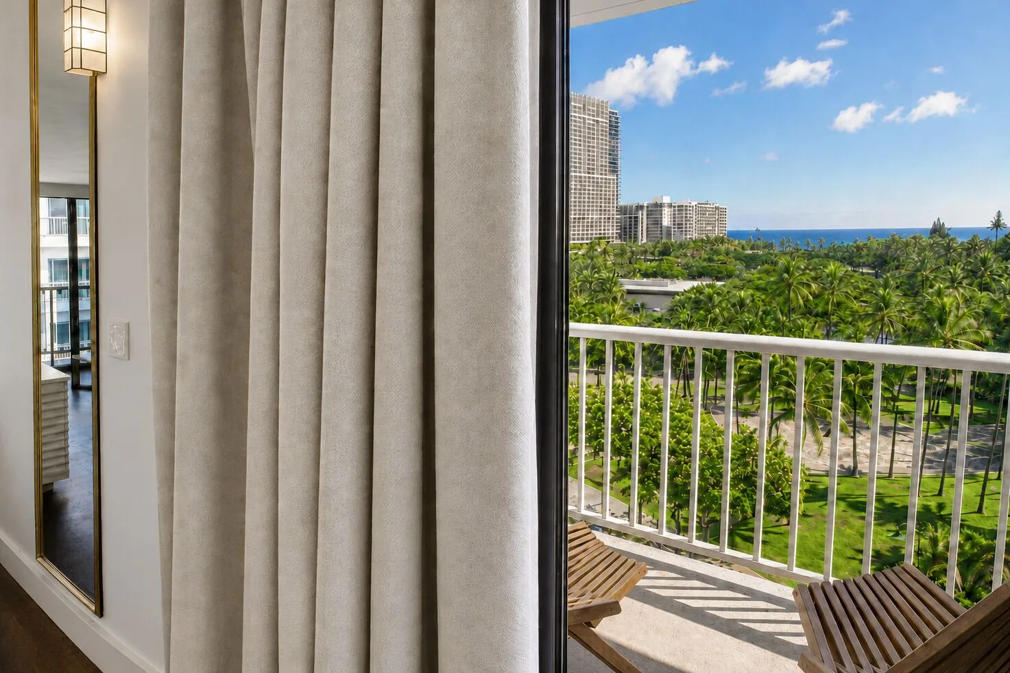 Oceanview lanai with palm trees and skyline in a Premium Kalakaua Haus room at Hotel La Croix.
