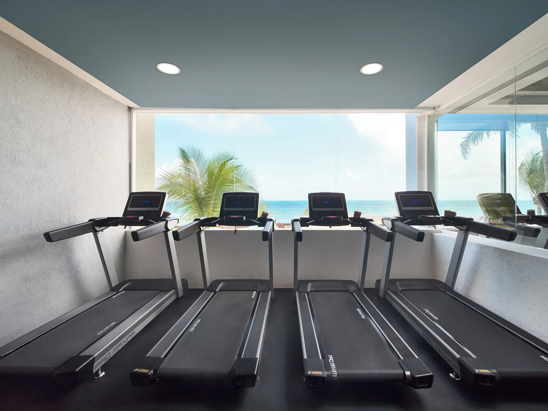 Treadmills overlook the ocean in the fitness room at Hotel Marina El Cid Spa & Beach Resort.