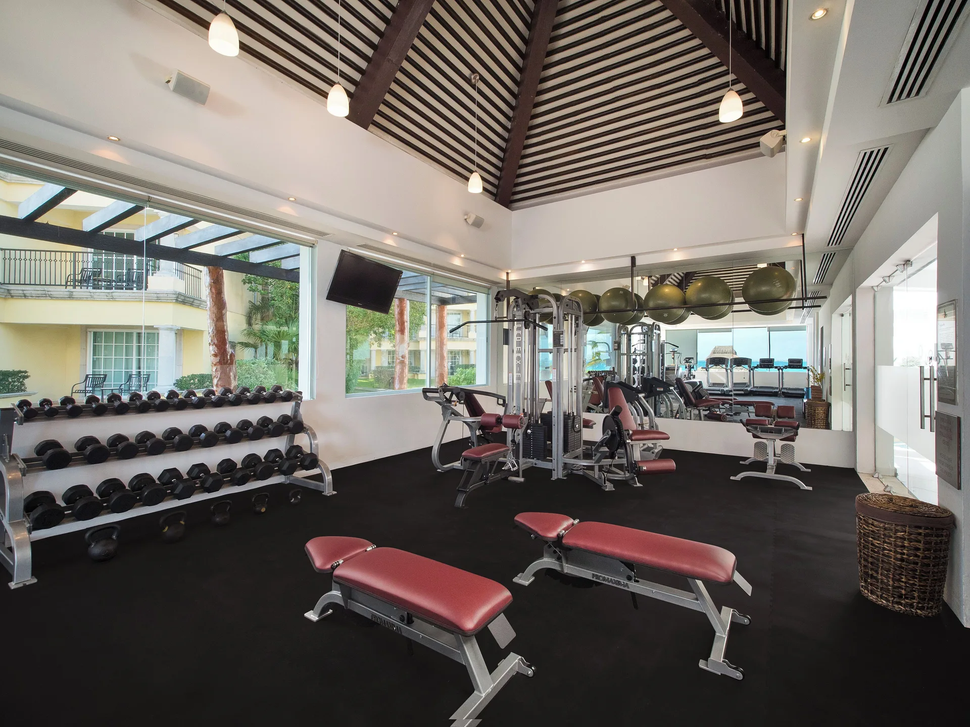 Weight benches and dumbbells in the fitness room at Hotel Marina El Cid Spa & Beach Resort.