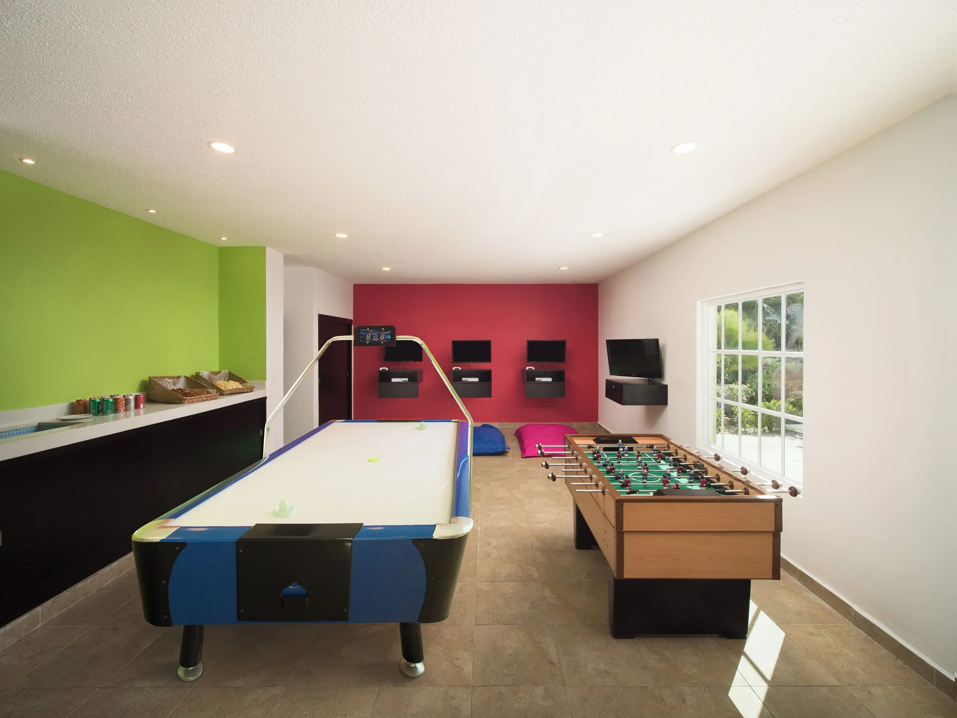 A bright game room with air hockey and foosball at Hotel Marina El Cid Spa & Beach Resort.