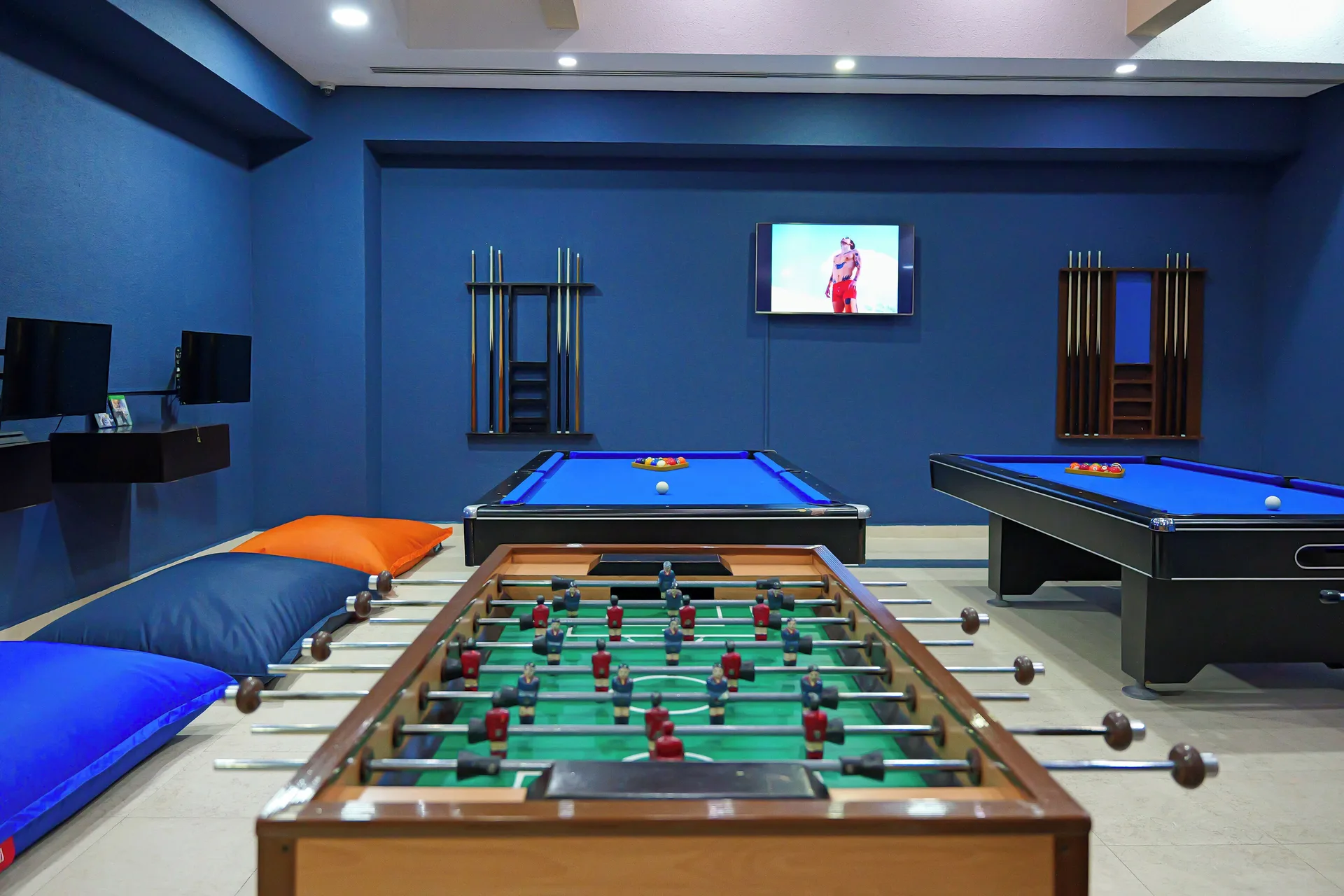 Game room with foosball, pool tables and TV at Hotel Marina El Cid Spa & Beach Resort.