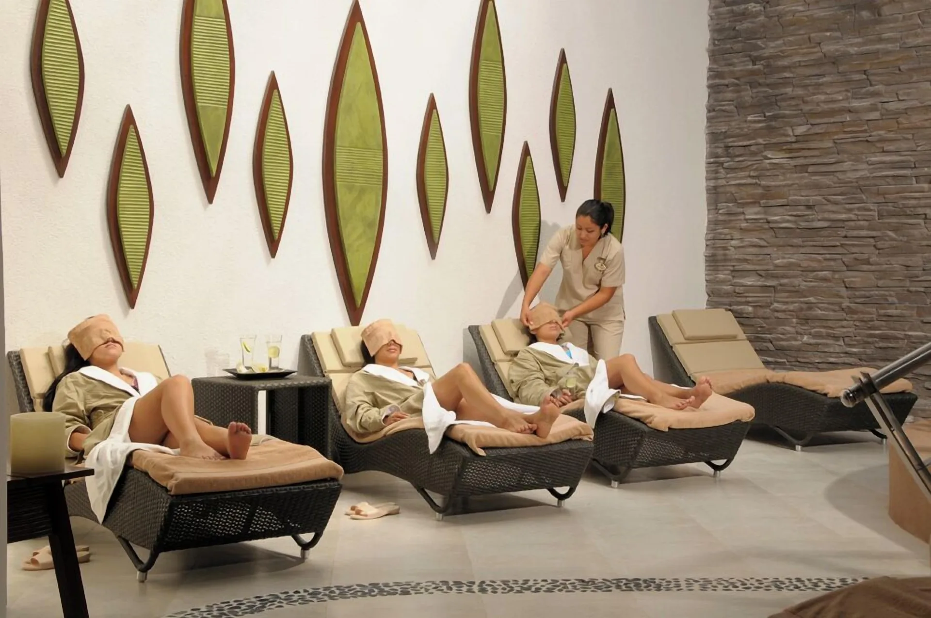 Spa lounge chairs with guests resting indoors at Hotel Marina El Cid Spa & Beach Resort.