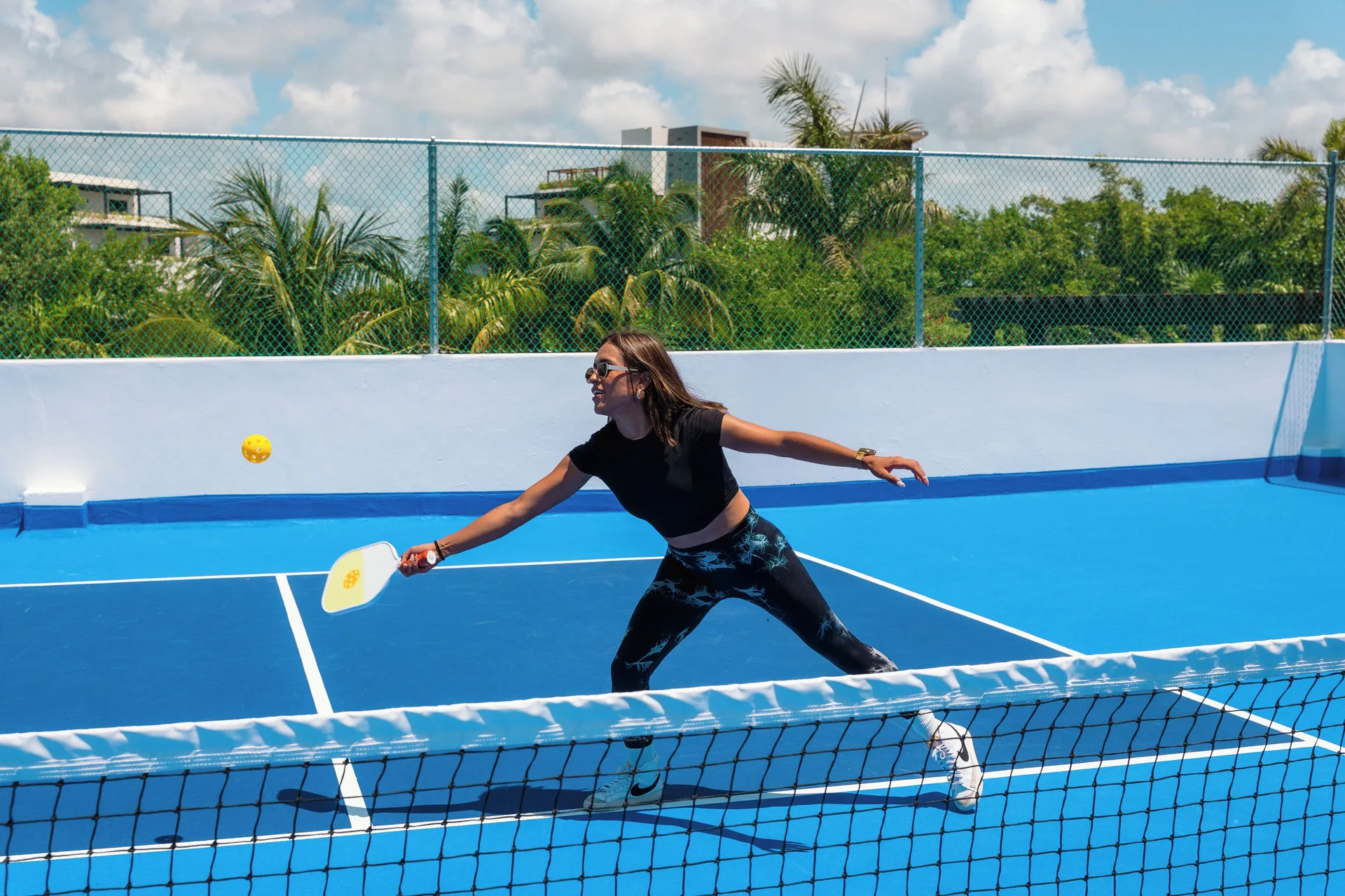 Guest playing pickleball on a blue court at Hotel Marina El Cid Spa & Beach Resort.