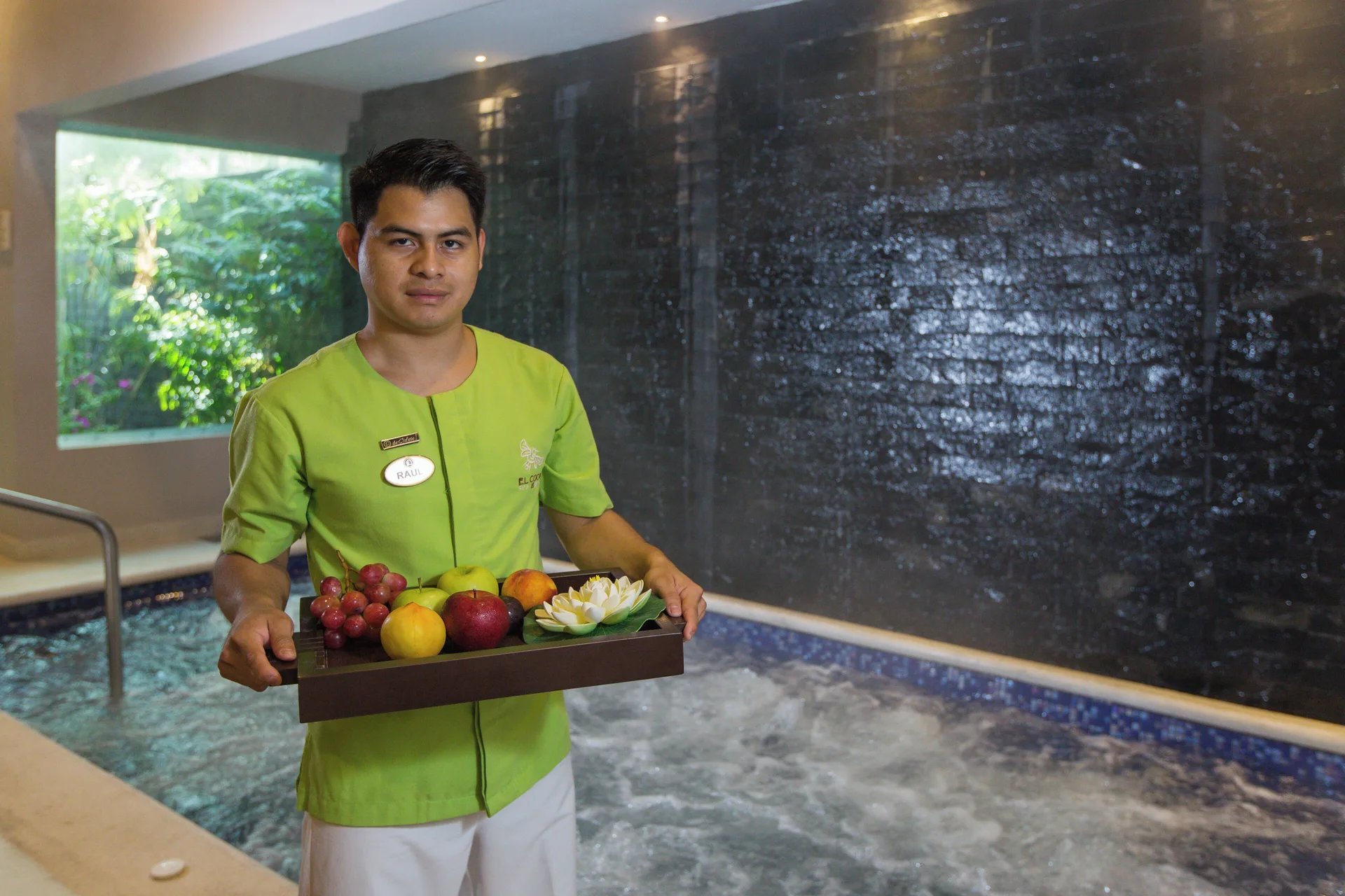 Spa attendant presents a fruit tray by a whirlpool at Hotel Marina El Cid Spa & Beach Resort.