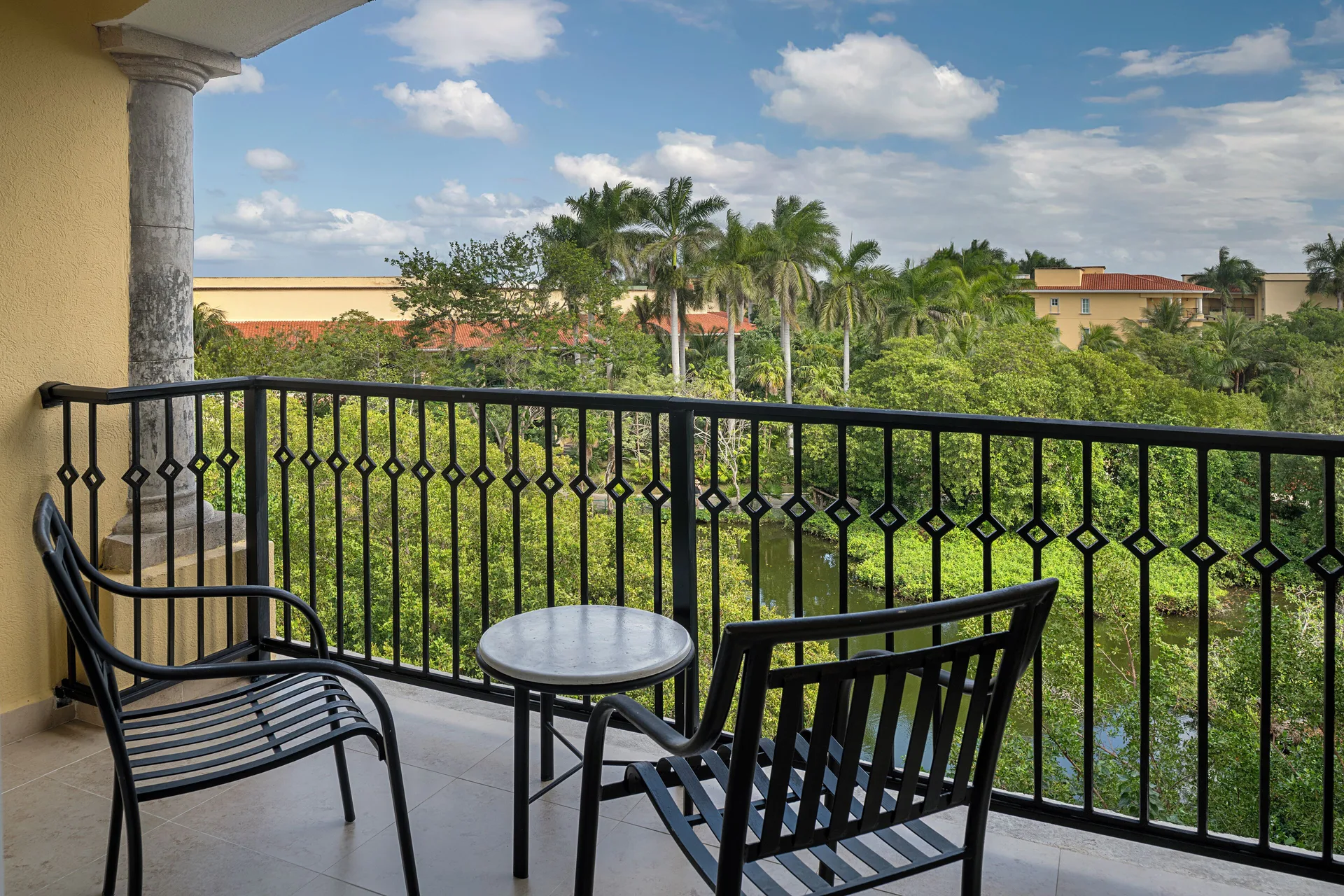 Luxury Room balcony with chairs and garden view at Hotel Marina El Cid Spa & Beach Resort.