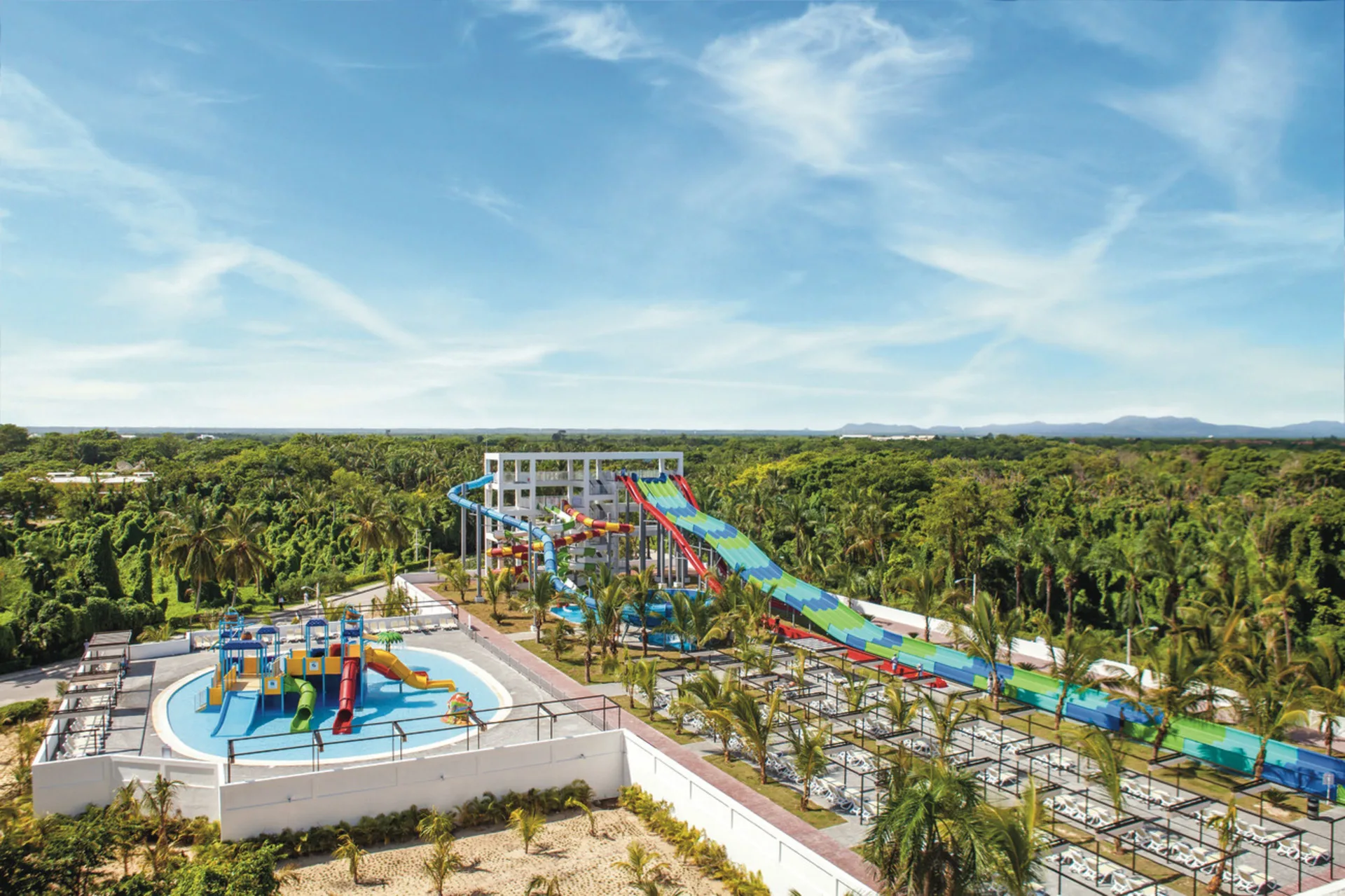 Wide aerial view of water slides and splash pool at Hotel Riu Bambu.