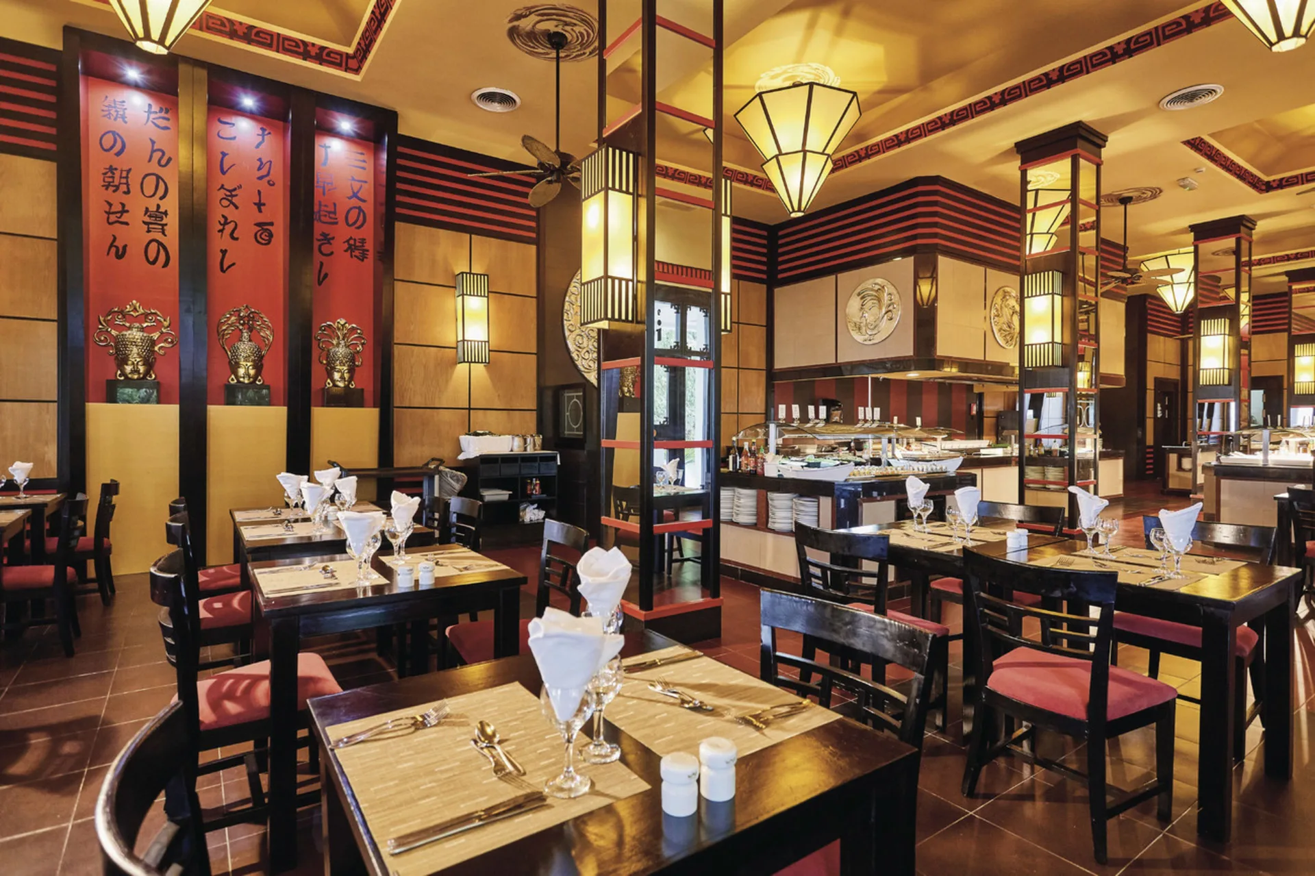 Asian-themed restaurant with buffet stations and lanterns at Hotel Riu Bambu.