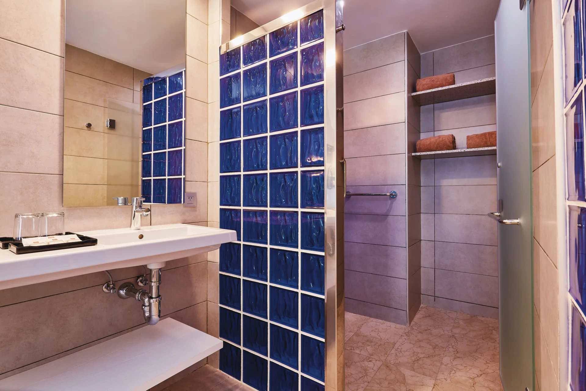 Family Room bathroom with sink, blue glass blocks and shower at Hotel Riu Bambu.