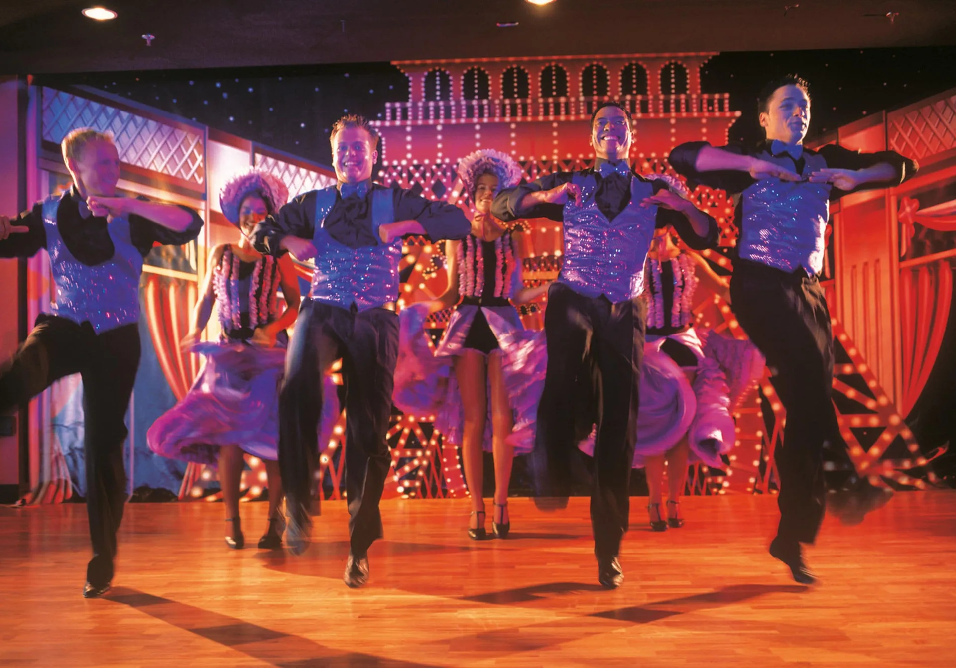 Dance troupe performing on an indoor stage at Hotel Riu Cancun.