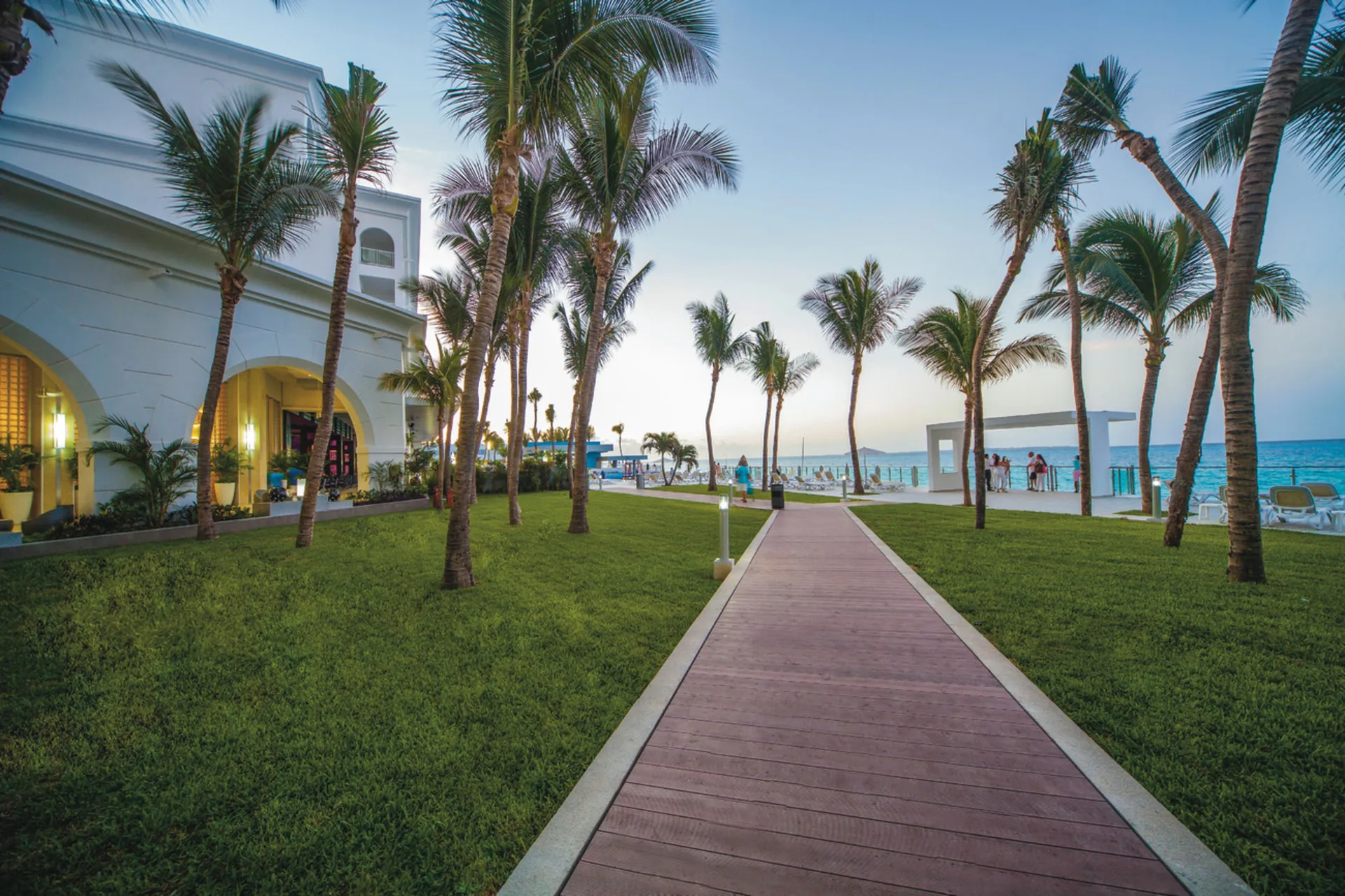 Palm-lined walkway leading toward the ocean at Hotel Riu Cancun.