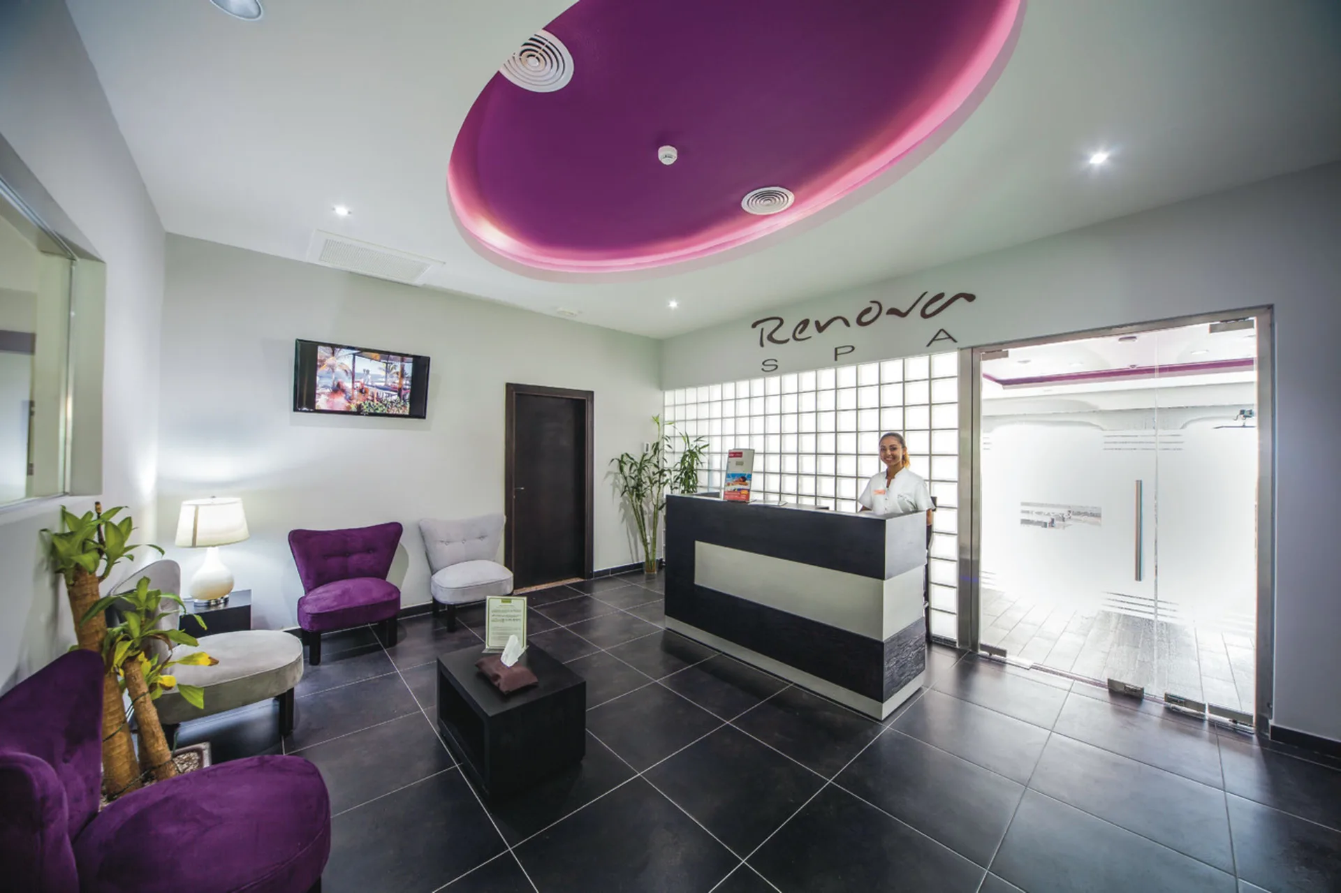 Spa reception with purple seating and front desk at Hotel Riu Cancun.