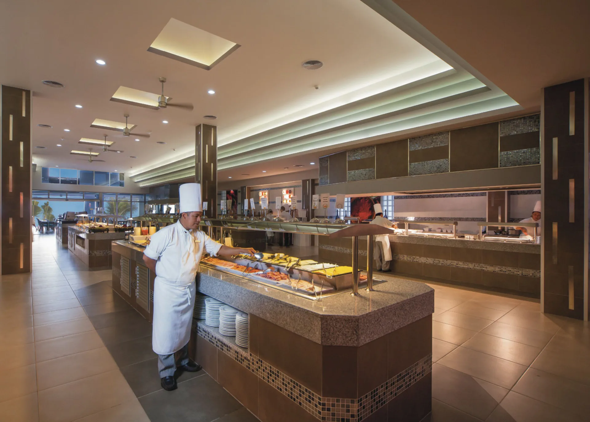 Buffet counter with a chef and serving stations at Hotel Riu Cancun.