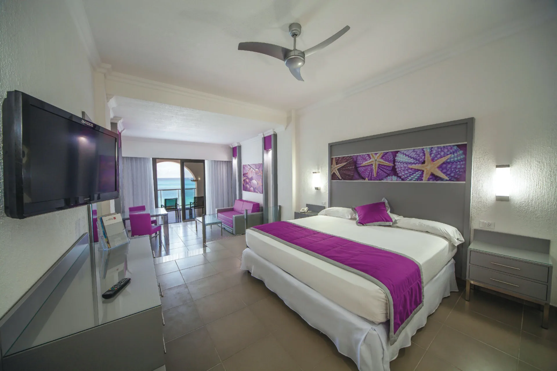 Junior Suite Ocean View guest room with king bed and balcony at Hotel Riu Cancun.
