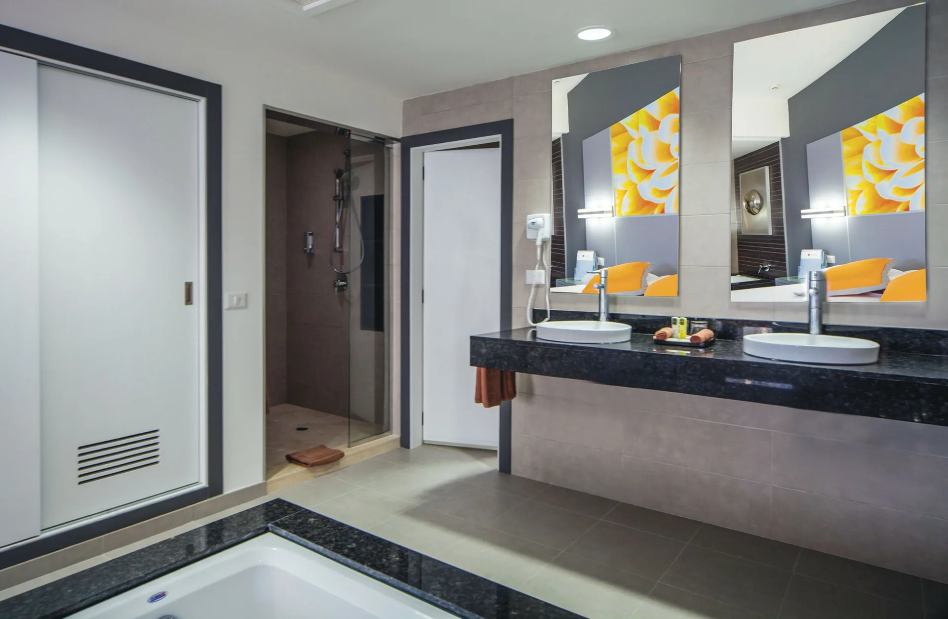 Suite Ocean View bathroom with double sinks, tub, and shower at Hotel Riu Cancun.