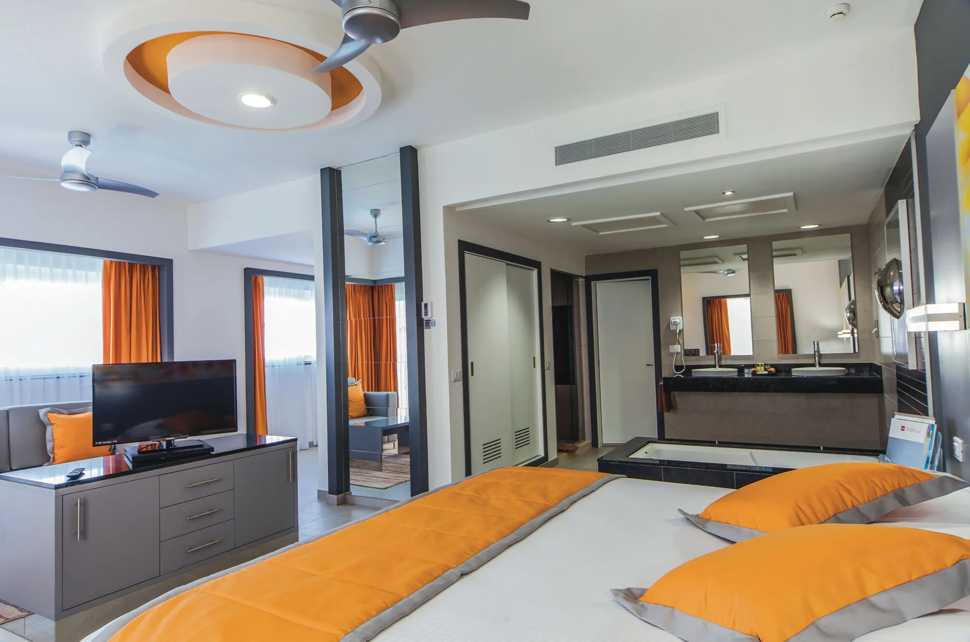 Suite Ocean View bedroom with TV and open bath area at Hotel Riu Cancun.