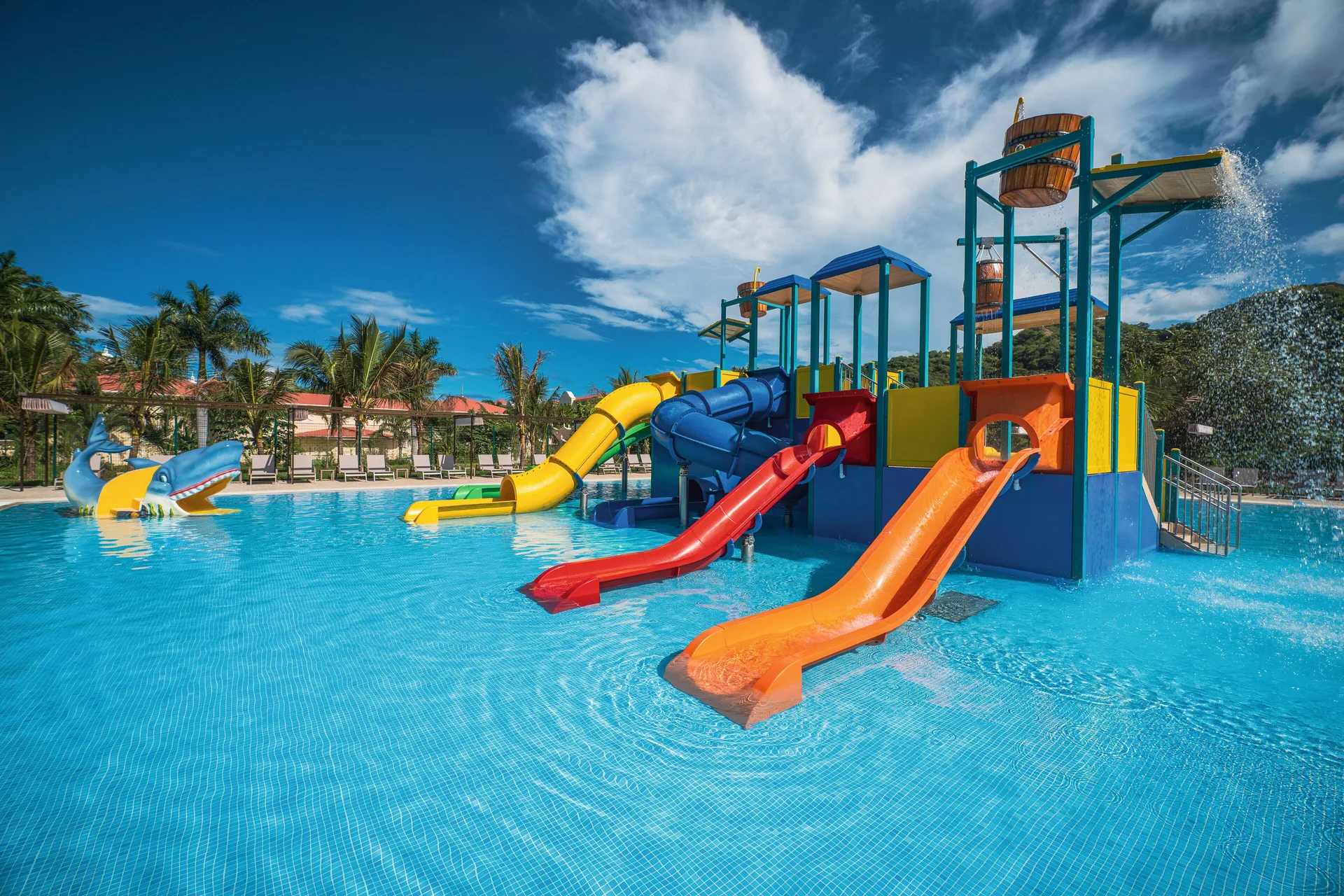 Colorful splash pool slides and tipping buckets at Hotel Riu Guanacaste.