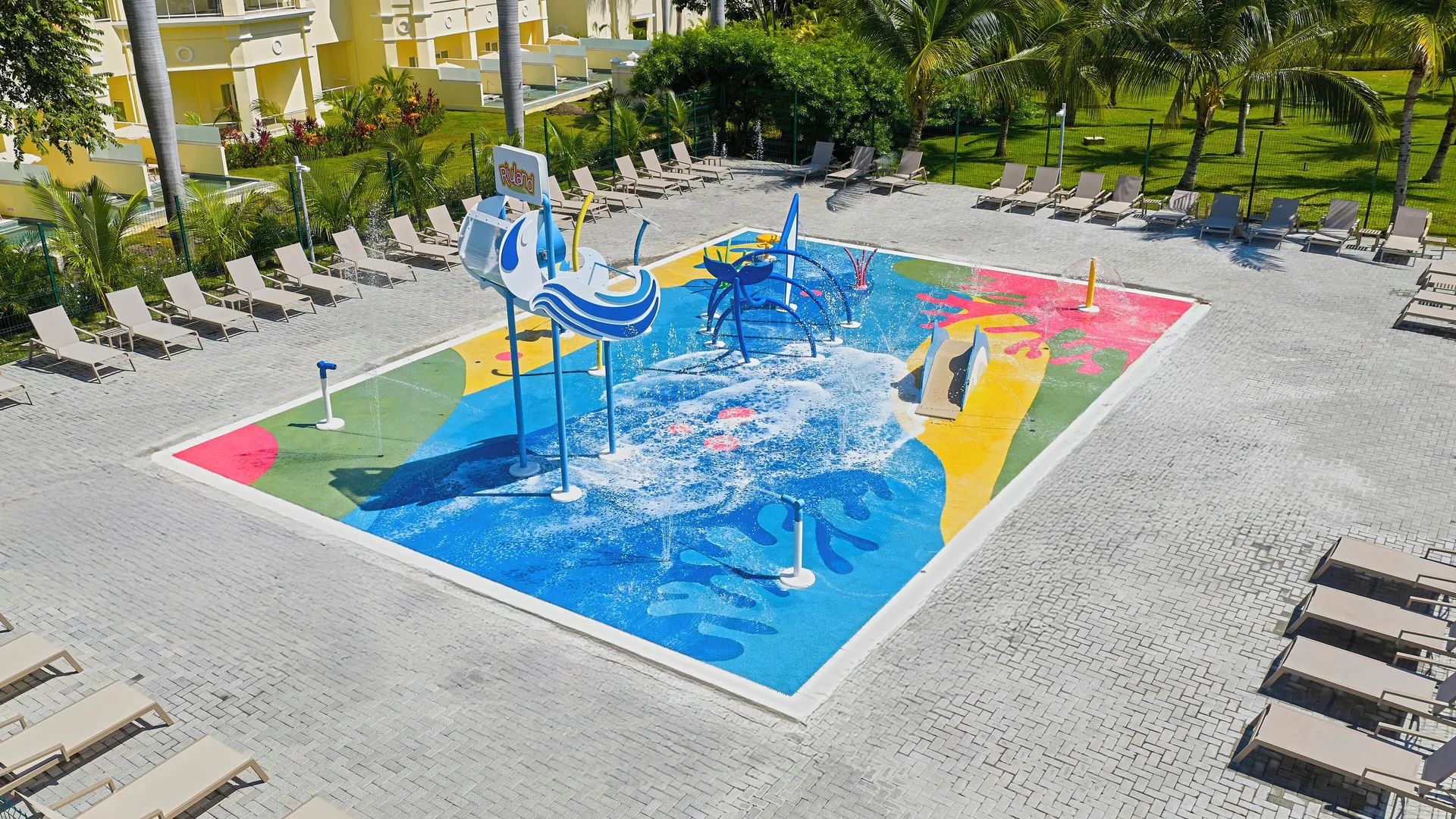Colorful splash pad with water sprays and loungers at Hotel Riu Guanacaste.