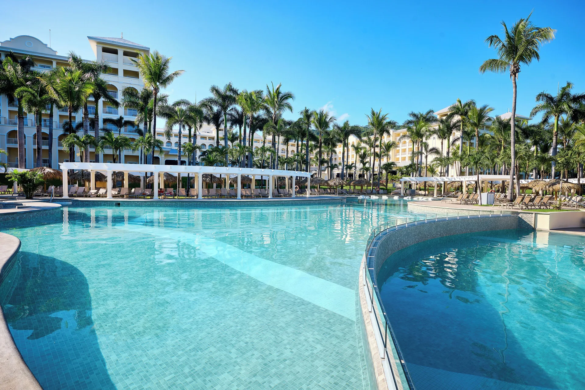 Expansive pool with palms, cabanas and resort buildings at Hotel Riu Guanacaste.