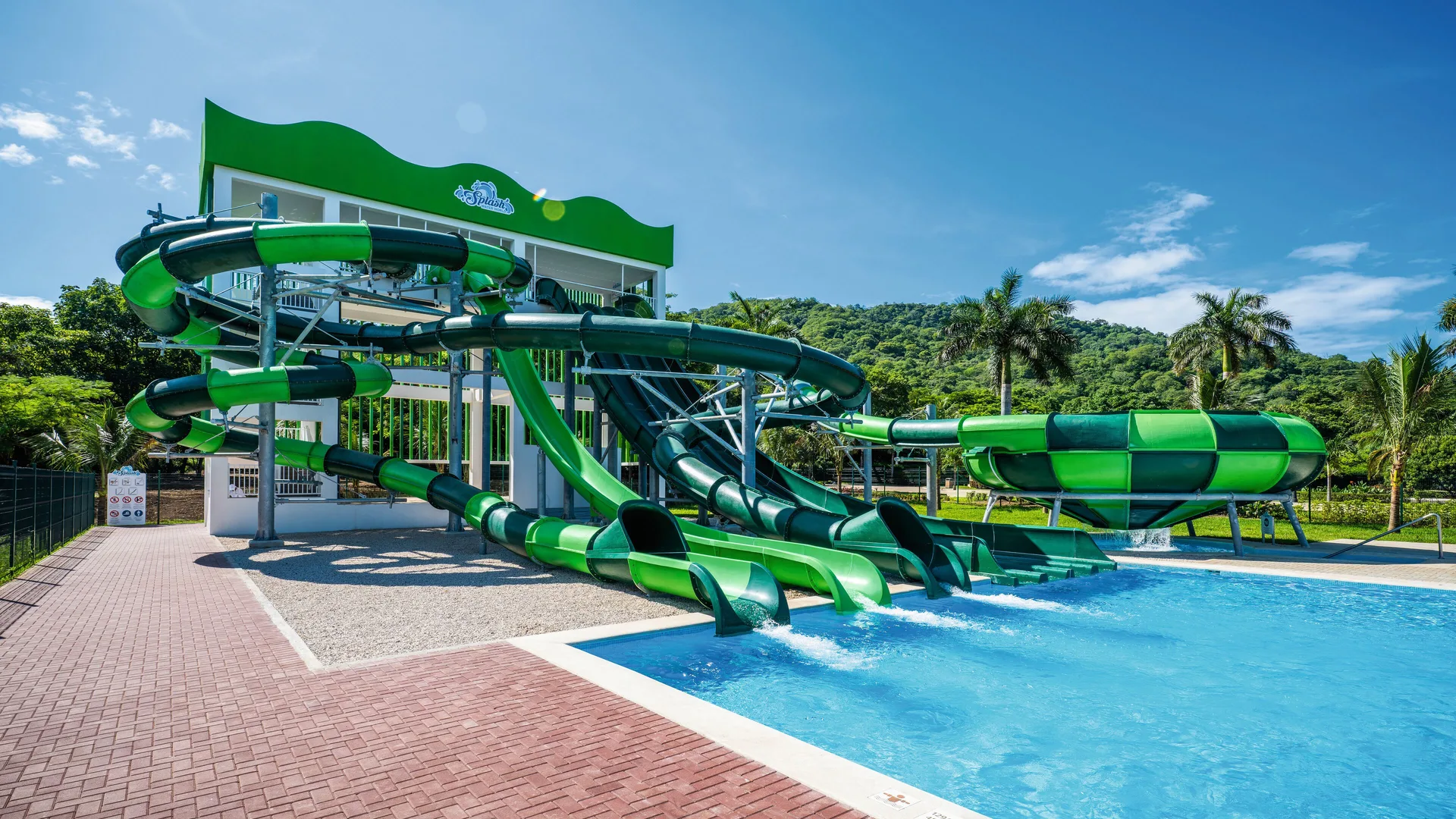 Green waterslides emptying into a pool at Hotel Riu Guanacaste.