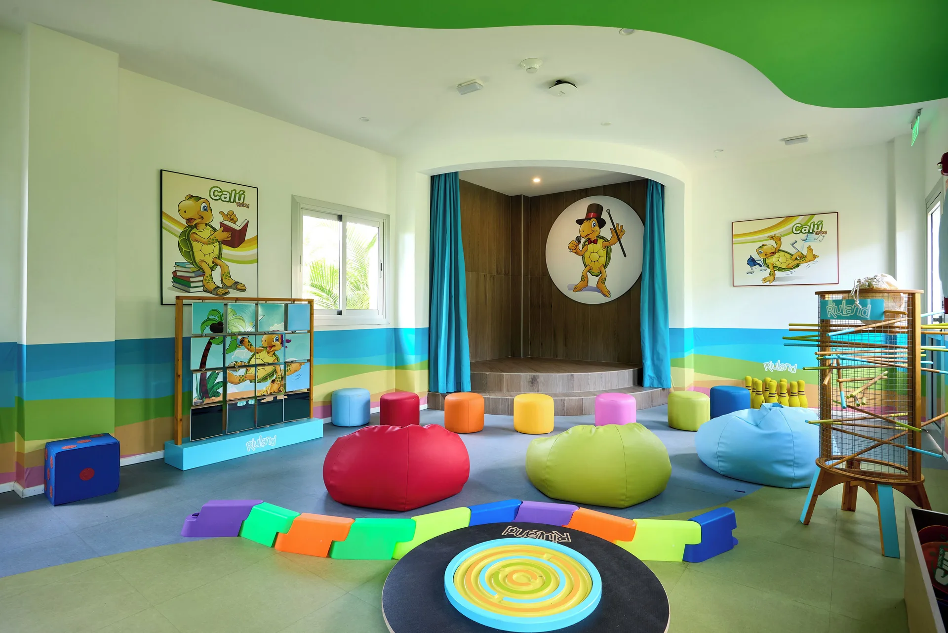 Colorful kids playroom with beanbags and small stage at Hotel Riu Guanacaste.