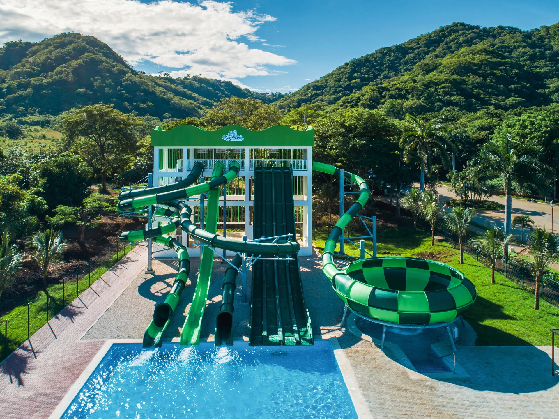 Large green water slide tower beside the pool at Hotel Riu Guanacaste.