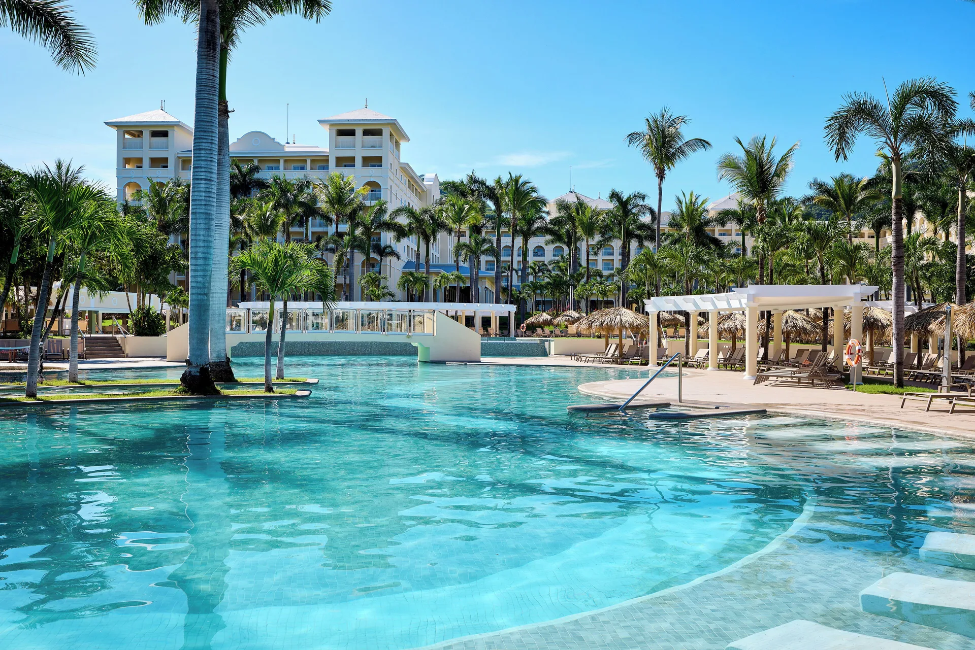 Main pool with palms, loungers and resort buildings at Hotel Riu Guanacaste.