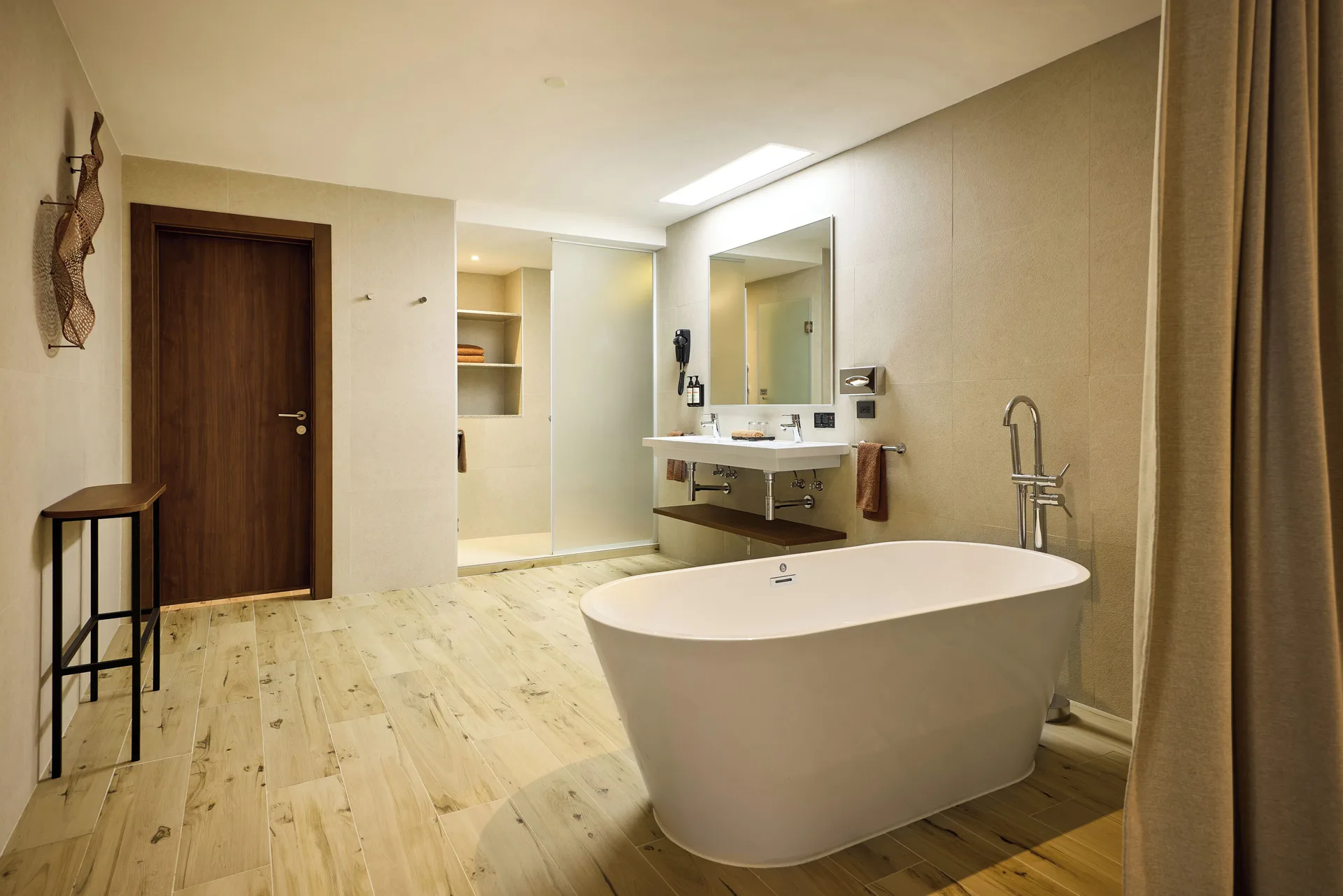 Bathroom with freestanding tub, vanity, mirror and walk-in shower at Hotel Riu Guanacaste.