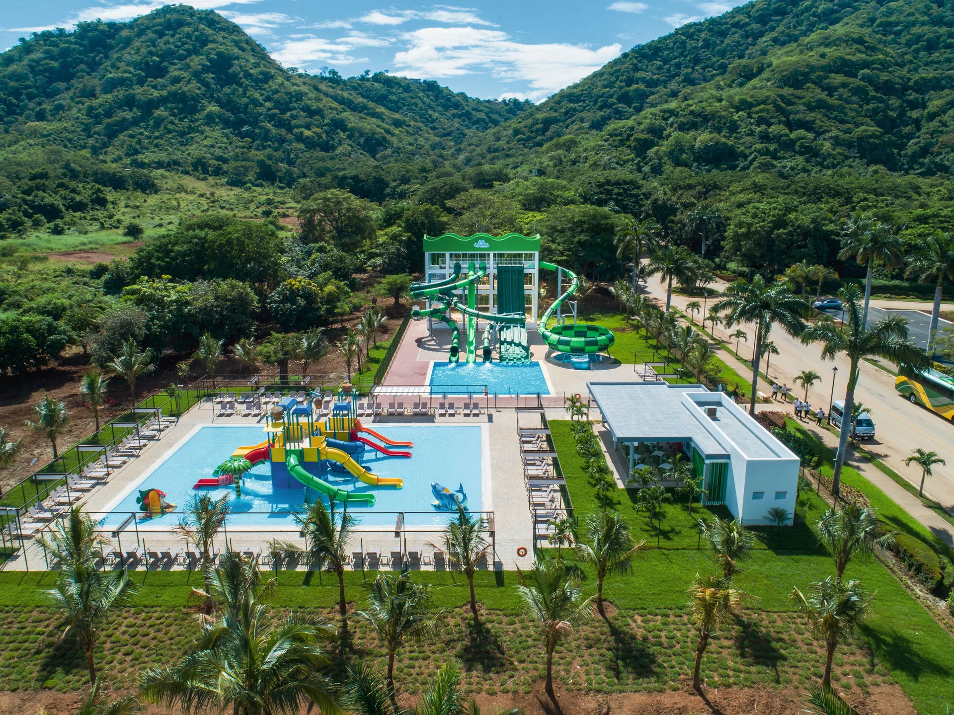 Aerial view of the water park set between green hills at Hotel Riu Guanacaste.