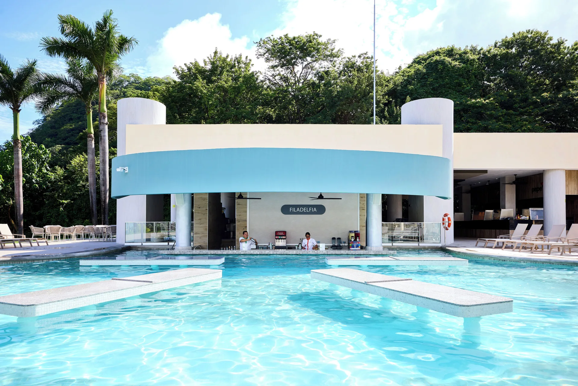 Filadelfia pool bar with blue canopy and swim-up counter at Hotel Riu Guanacaste.