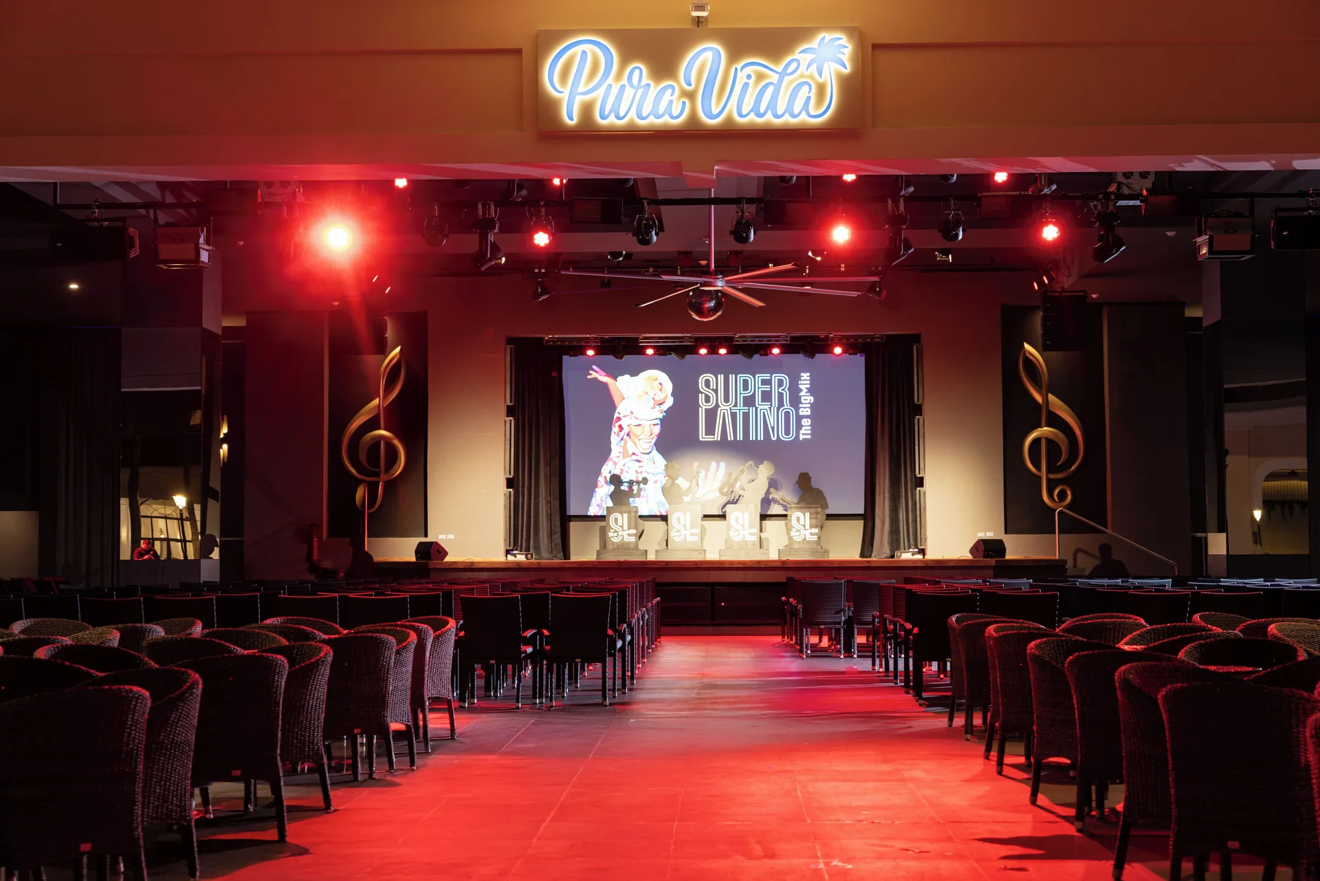 Pura Vida stage with rows of chairs and red lighting at Hotel Riu Guanacaste.