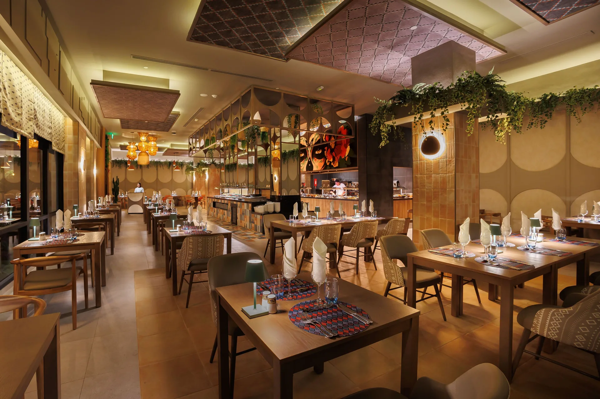 Warmly lit restaurant dining room with set tables at Hotel Riu Guanacaste.