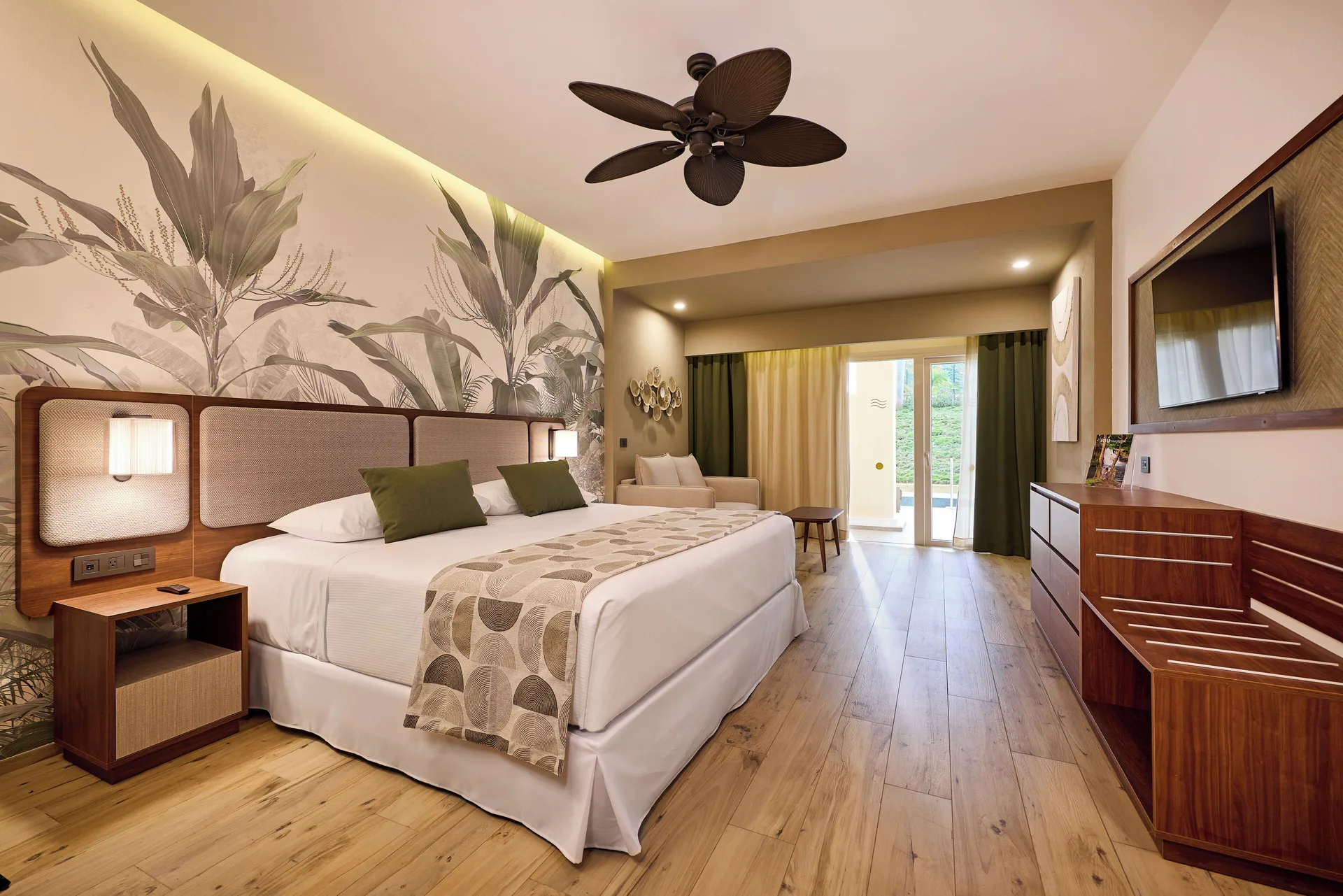 Swim-up adults-only room with king bed, TV, and patio doors at Hotel Riu Guanacaste.