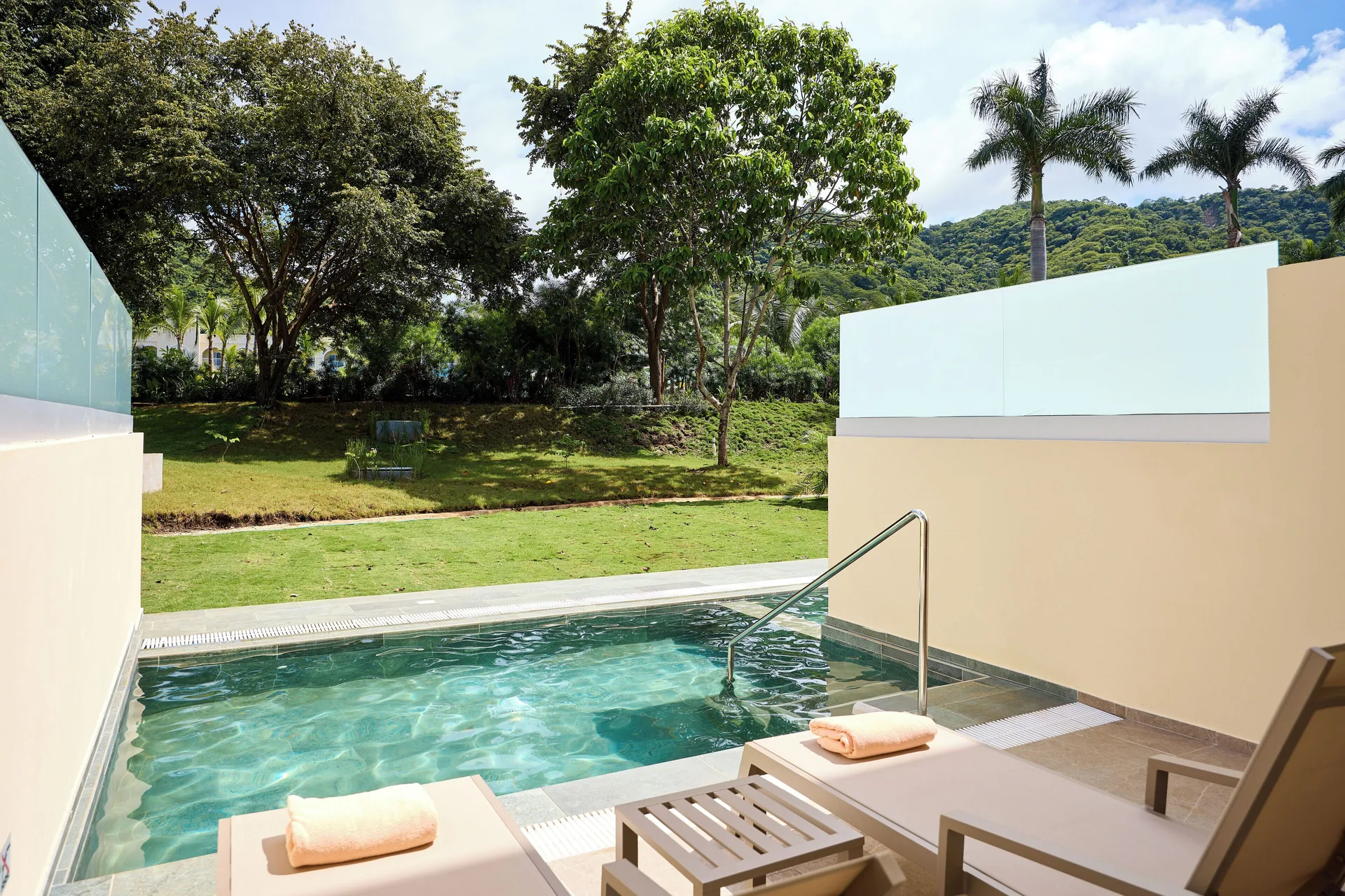 Private swim-up terrace with loungers and garden view at Hotel Riu Guanacaste.